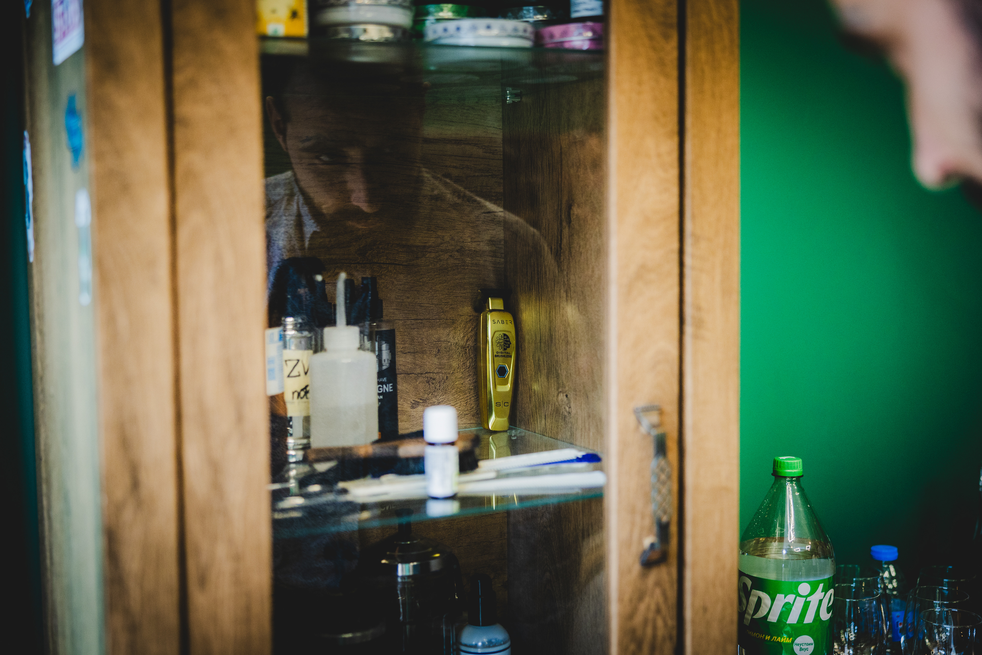 Подготовка на младоженеца в барбер студио – художествена сватбена фотография в Бургас. Детайлен кадър с отражение и машинка за подстригване, заснет от сватбен фотограф Габриел Александров.