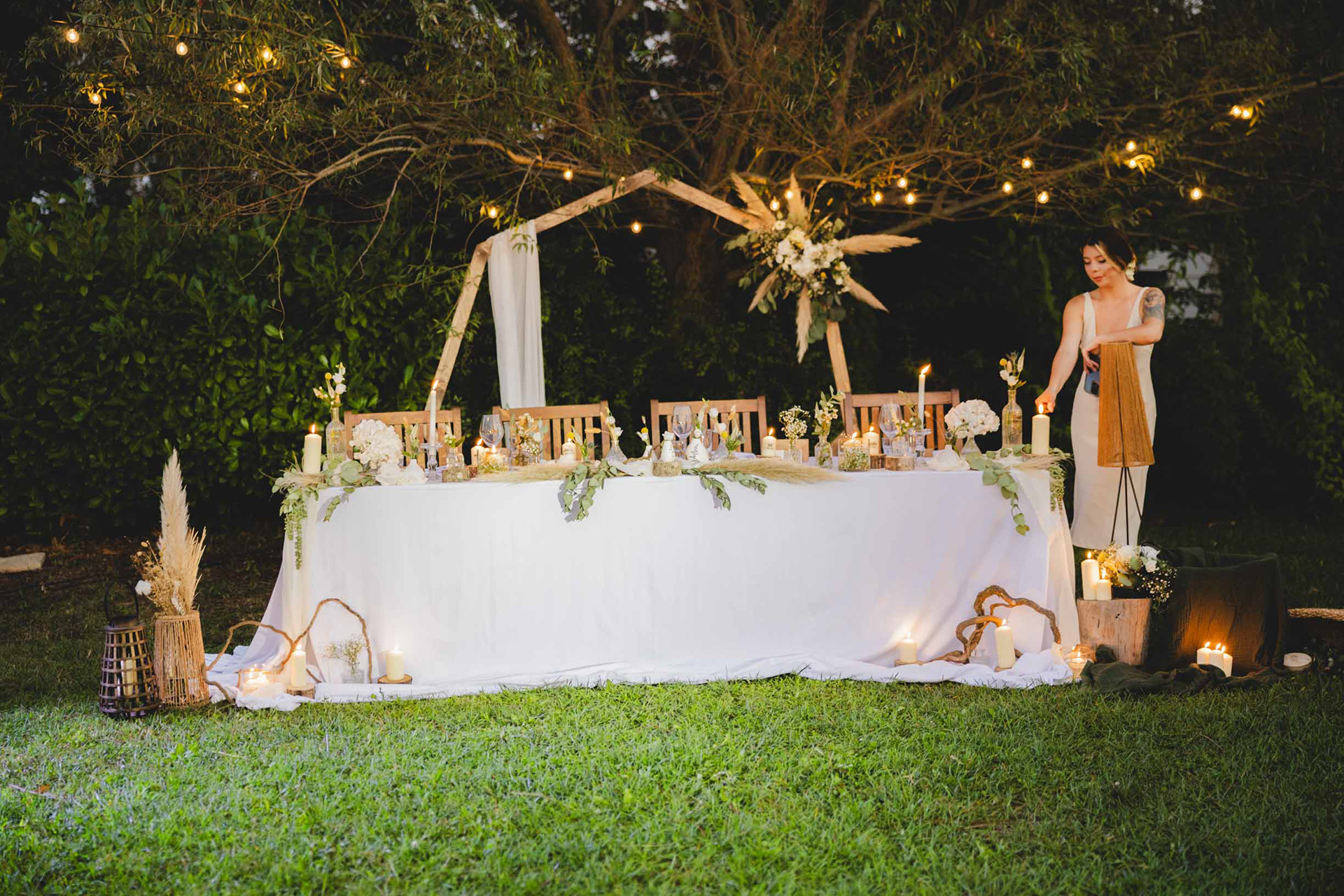 Младоженска маса с дървена сватбена арка в бохо стил - Сватбена фотография