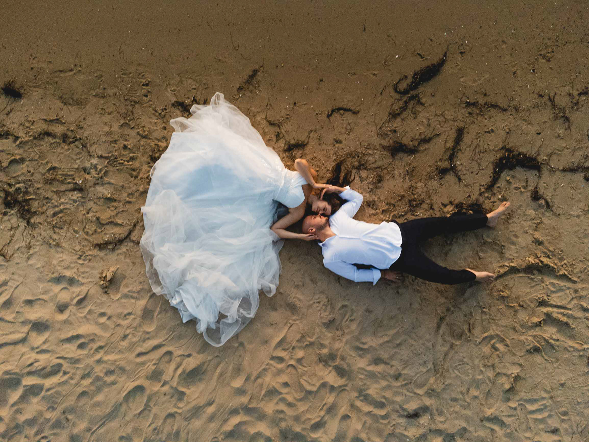 Прегърнати младоженци на плажа  в Несебър снимани с дрон от сватбен фотогарф