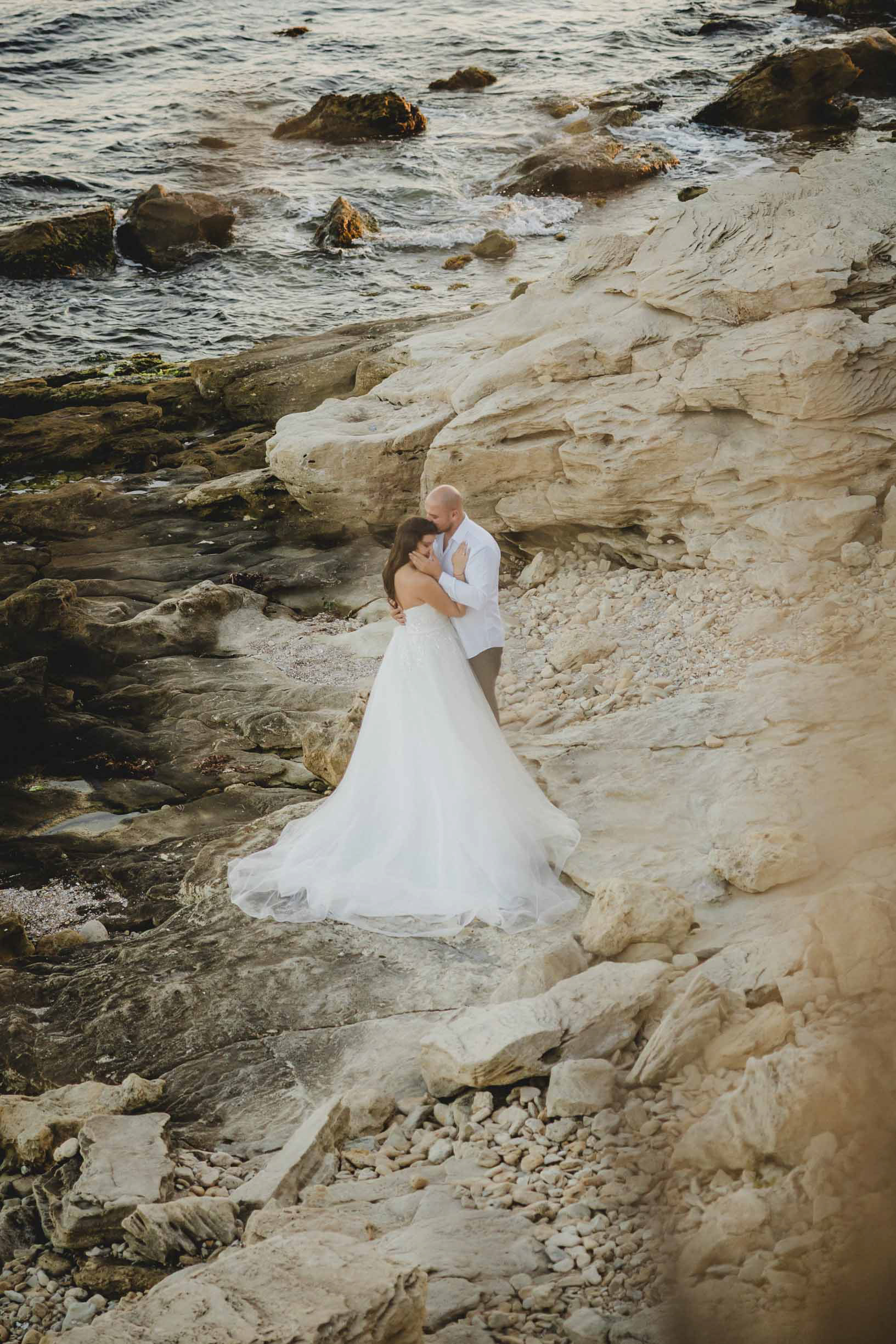 Сватбен фотограф Несебър: Интимна целувка на младоженци по залез на дюните. Естествена сватбена фотография от Габриел Александров.