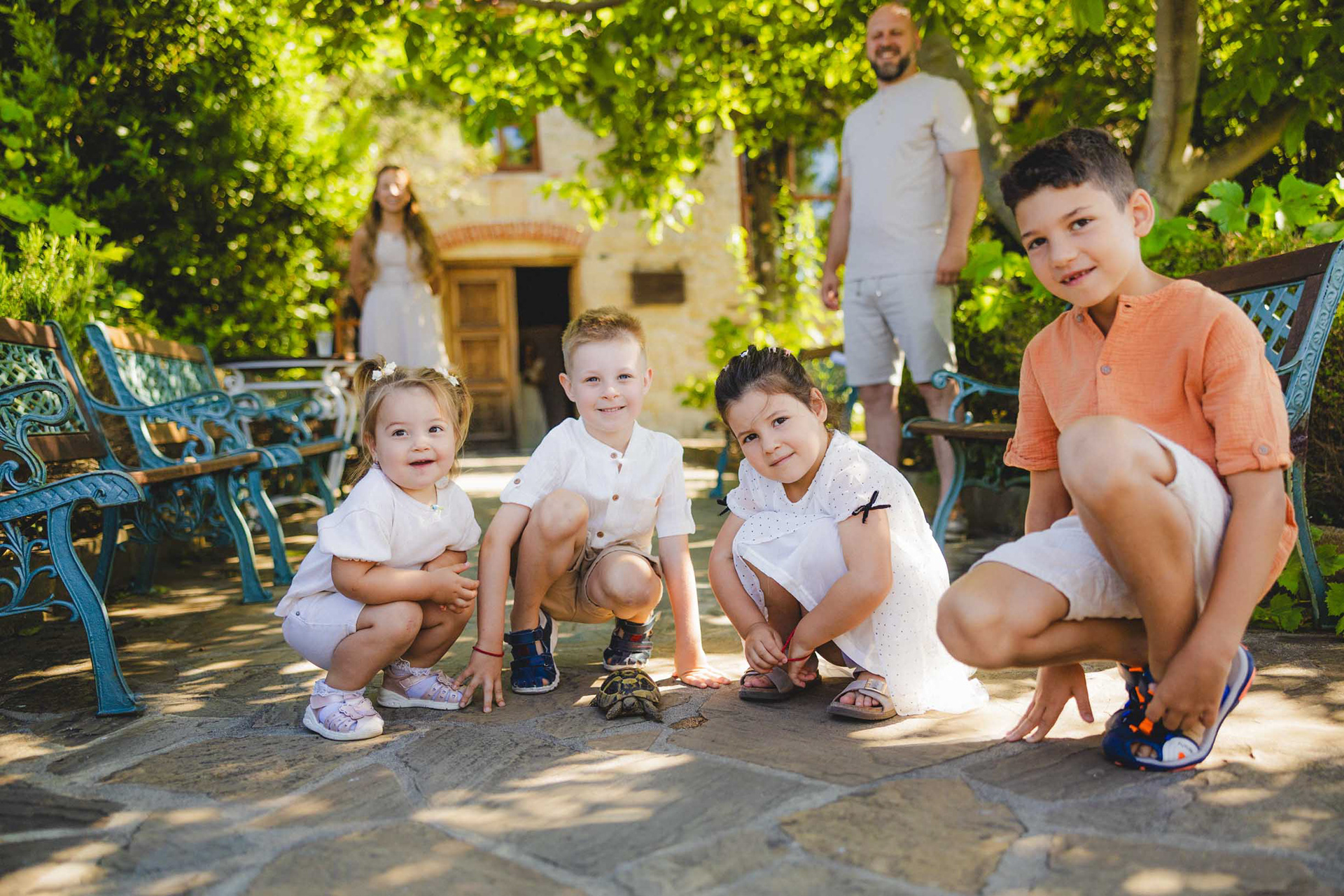 Деца позират с костенурка пред църква „Св. Успение Богородично”  във Василико пред професионален фотограф.