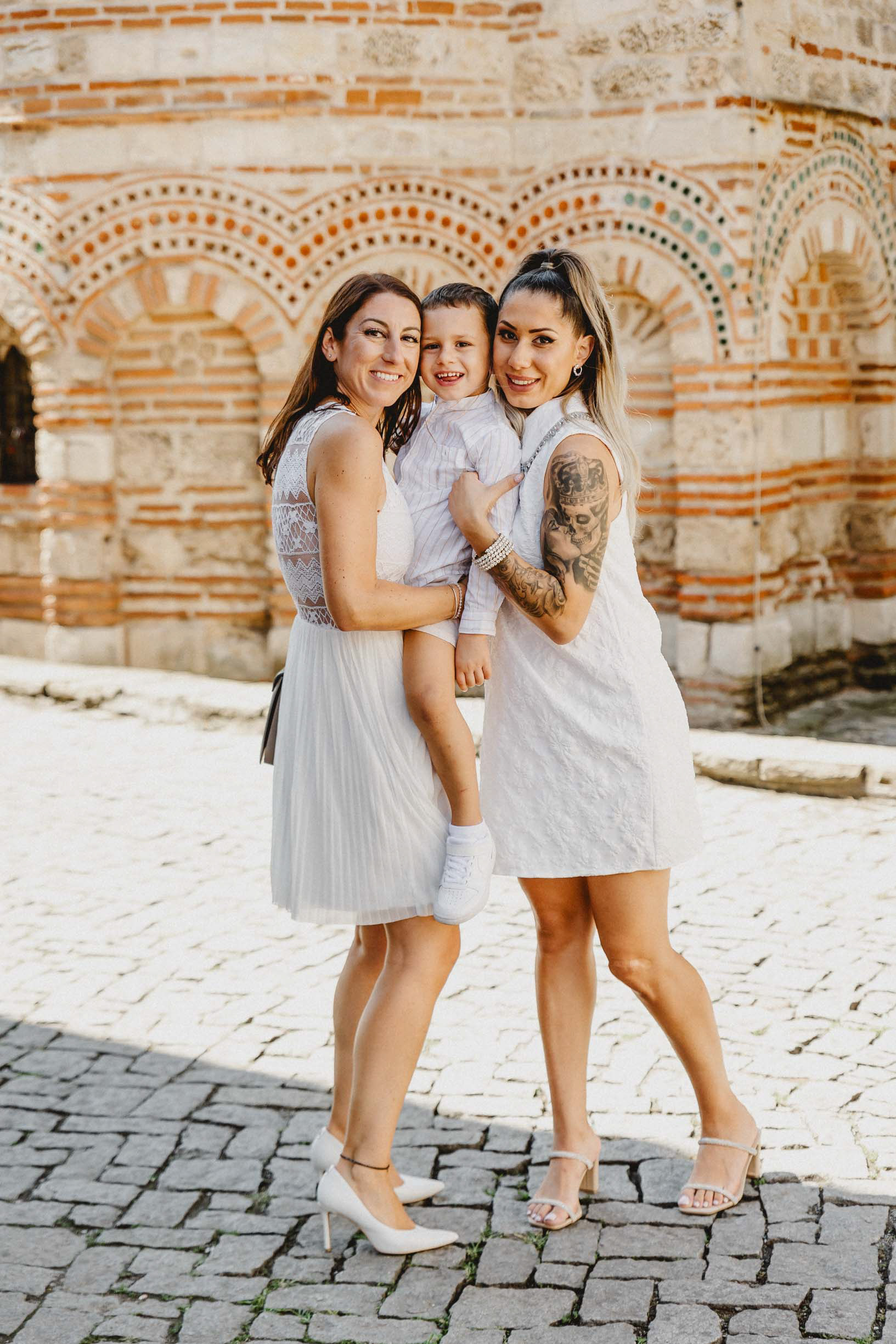 Семейна фотосесия пред византийската архитектура на храм в Несебър след ритуал по Свето Кръщение.