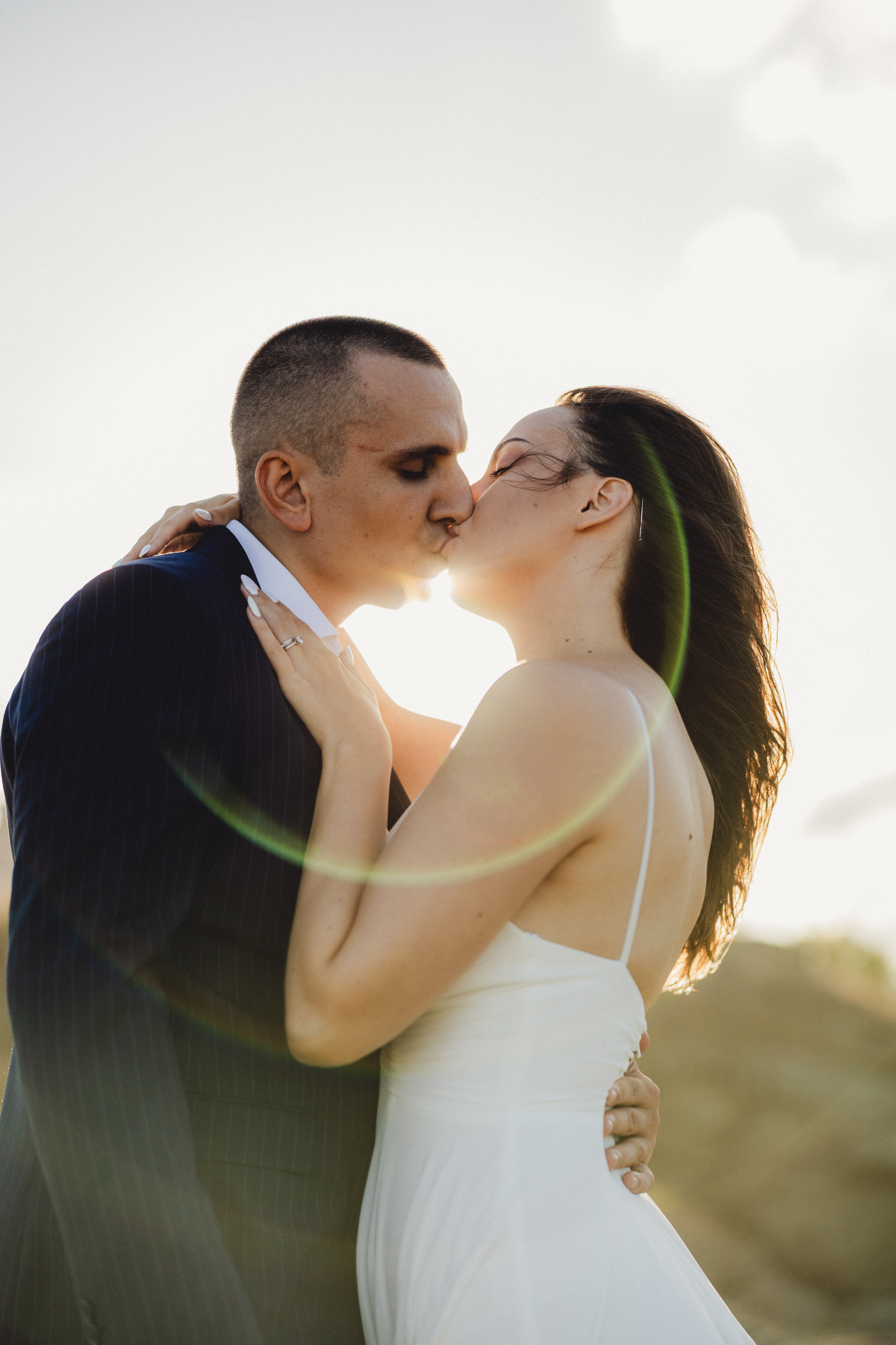 Романтична сватбена сесия на скалите в Царево – младоженци в интимен момент, погалени от нежните слънчеви лъчи, заснет от Габриел Александров.