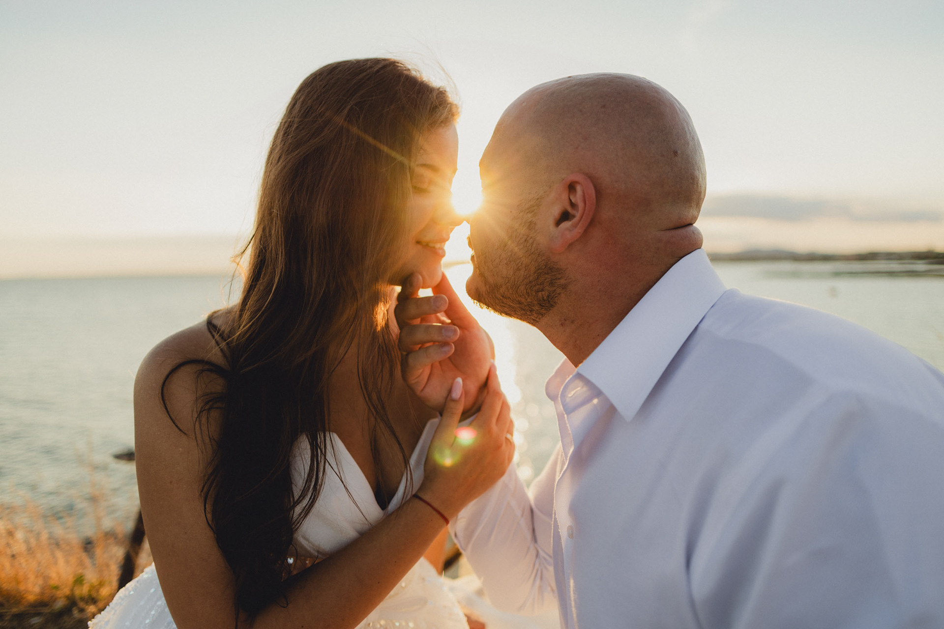 Сватбена фотография на скалите в Стария Несебър по залез. Романтичен портрет в контражур на фона на морето, заснет от сватбен фотограф Несебър – Габриел Александров