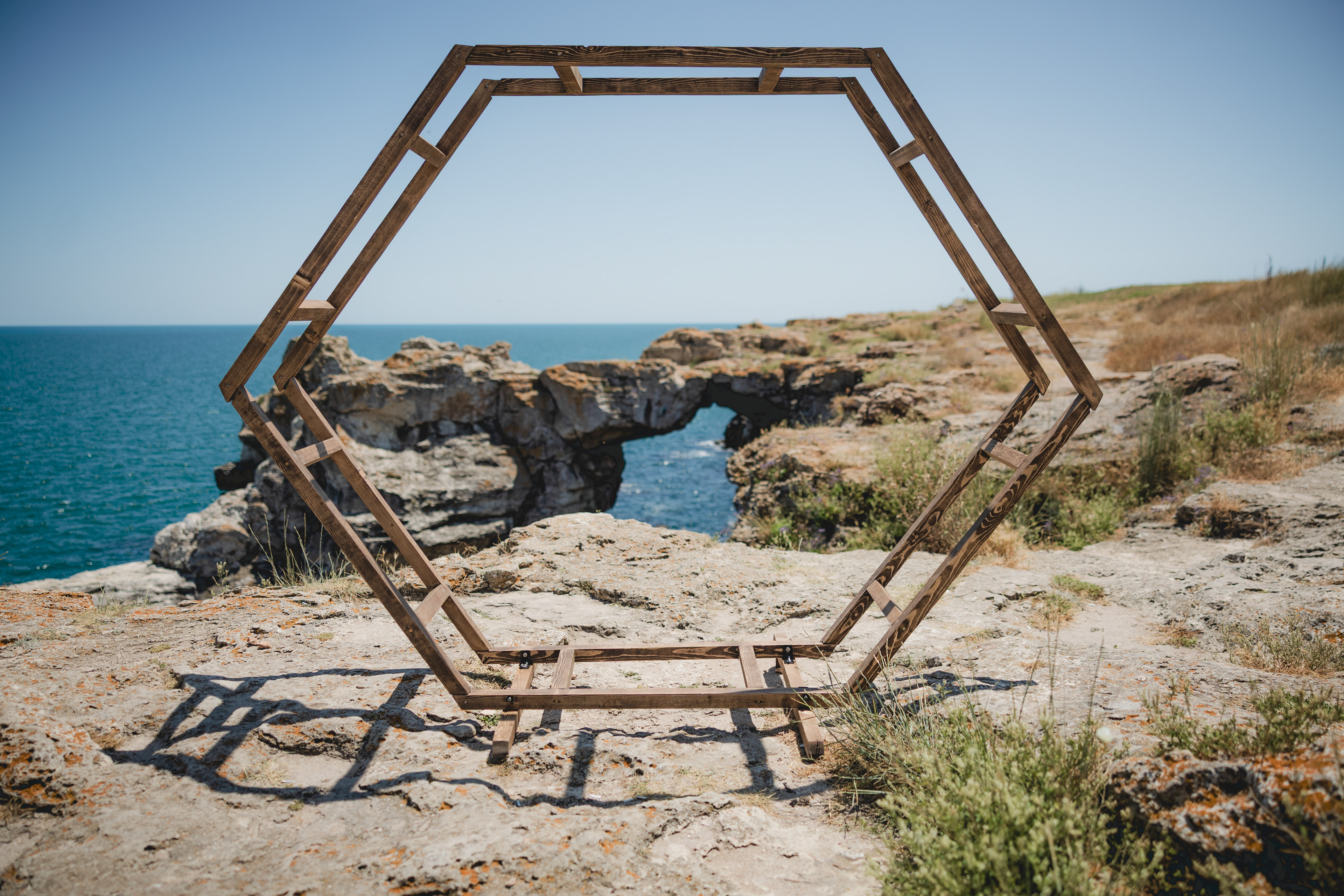 Двойна шестоъгълна сватбена арка на фона на арката в Тюленово, област Варна.