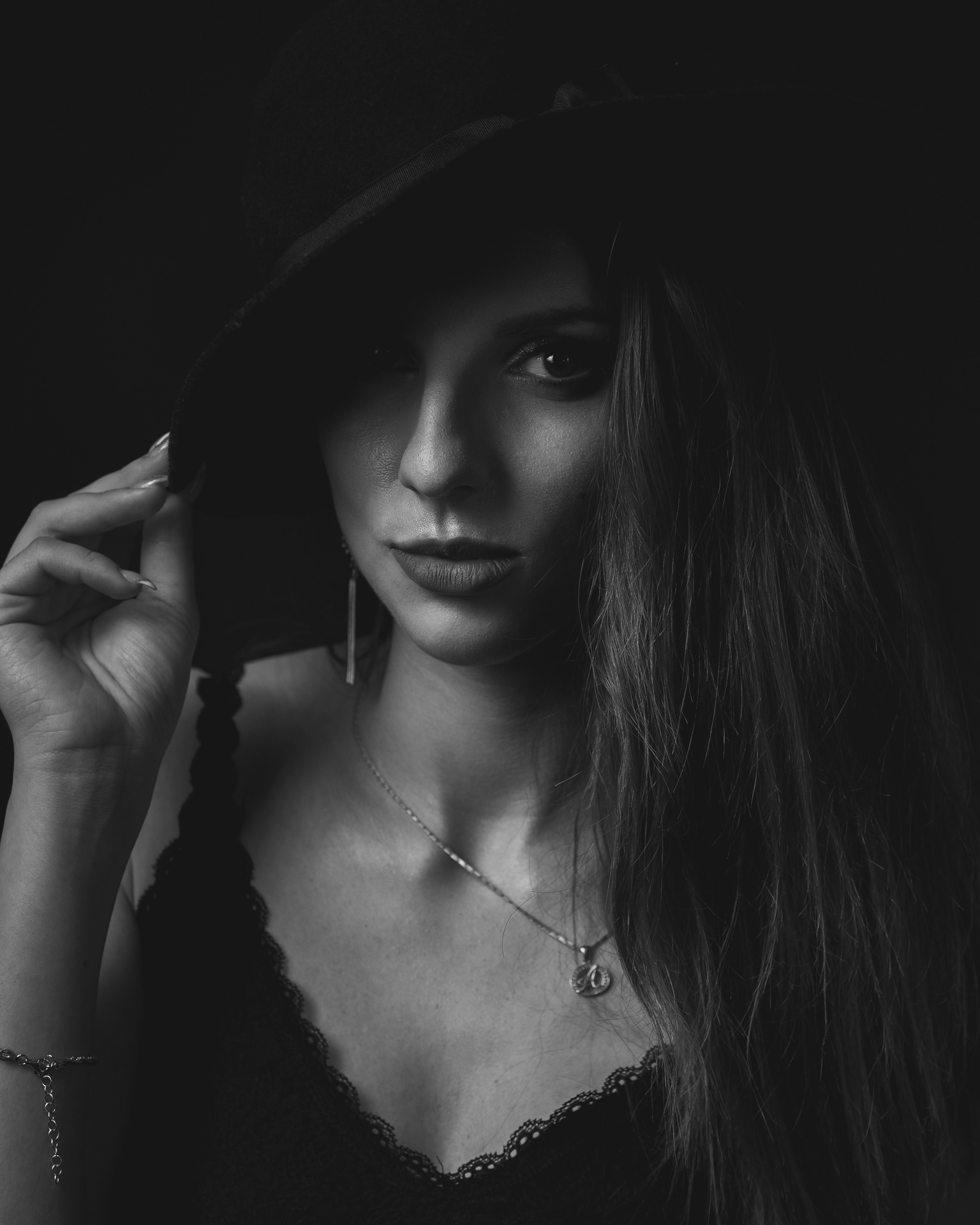 Sesja studyjna - czarno-biały portret kobiety na czarnym tle. Fotograf Warszawa