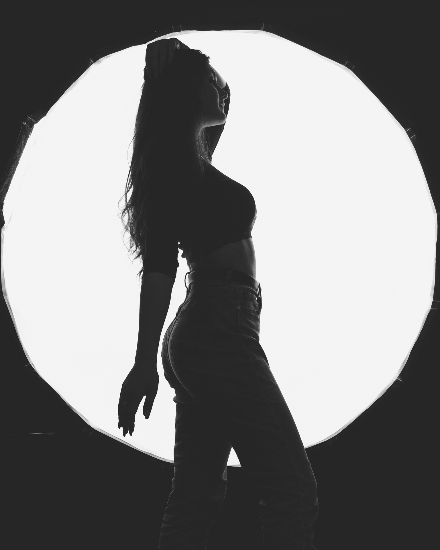 Sesja studyjna - czarno-biały artystyczny portret kobiety na tle lampy błyskowej. Fotograf Warszawa