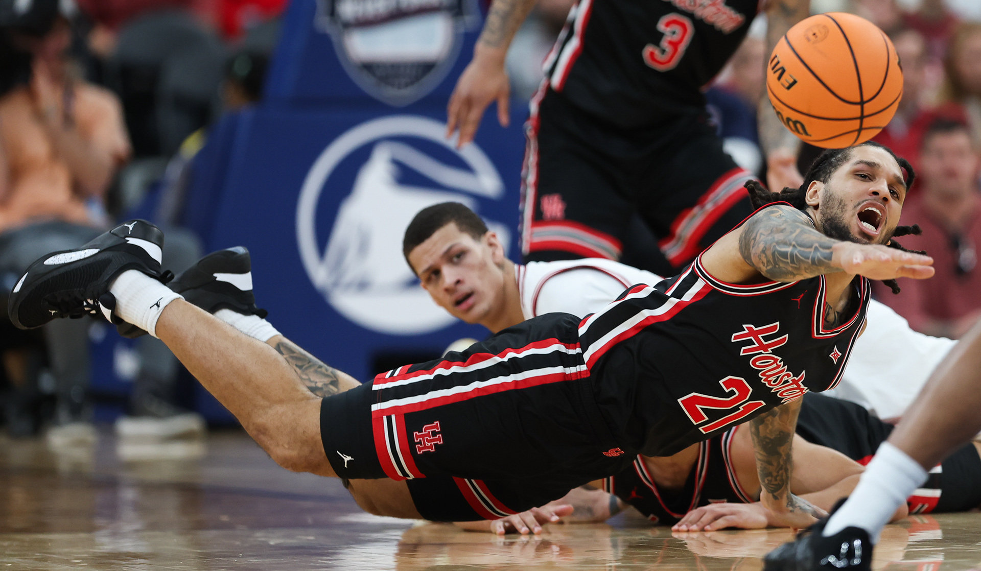 Newark, NJ - University of Houston Redshirt Senior Guard #21 Emanuel Sharp attempts to dive for the ball during non-conference play against Arkansas in the Never Forget Tribute Classic '25  at the Prudential Center 