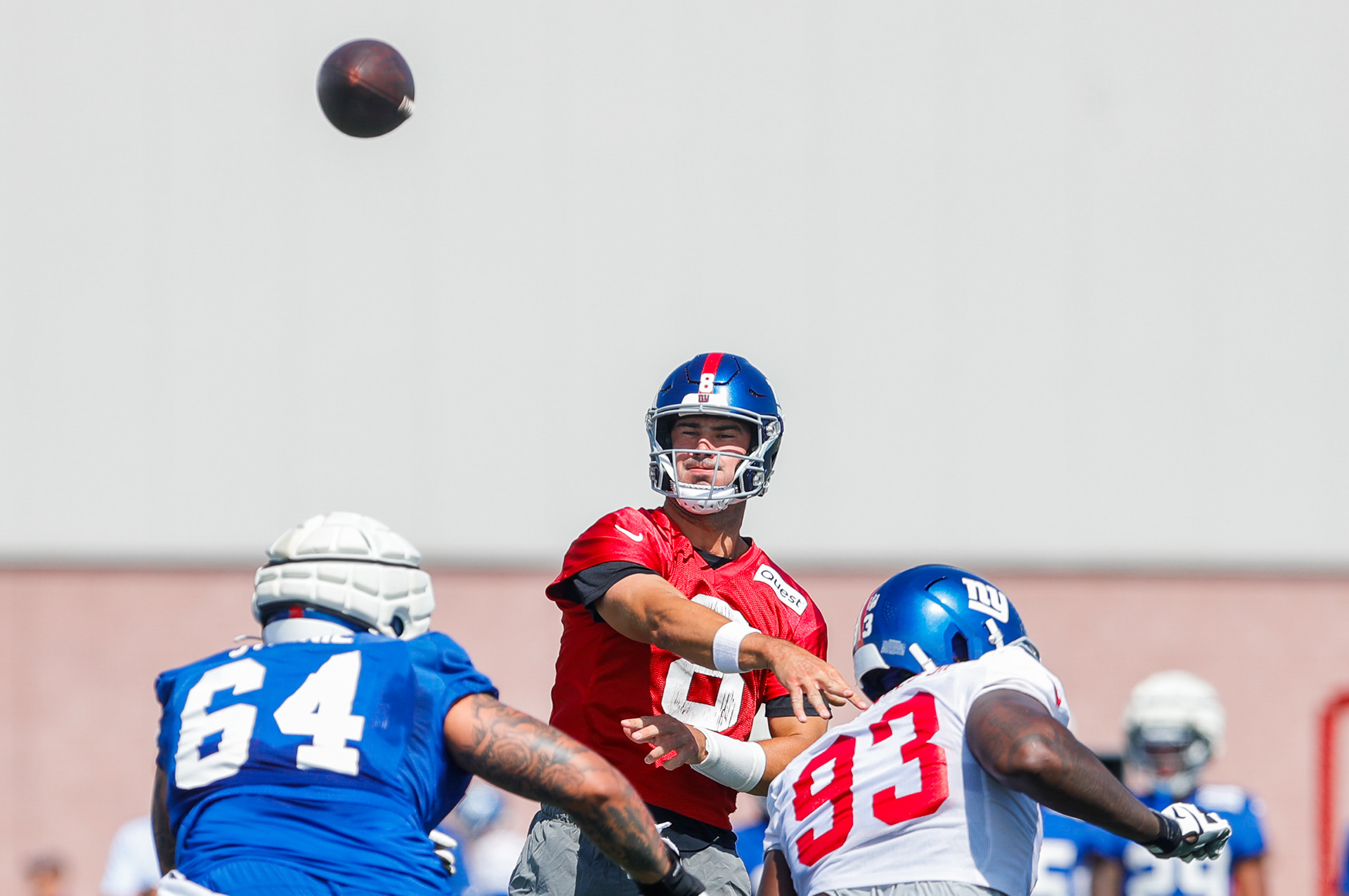 East Rutherford, NJ - Giants Quarterback #8 Daniel Jones throws while being rushed by the giants defensive line during Giants training camp 2024 