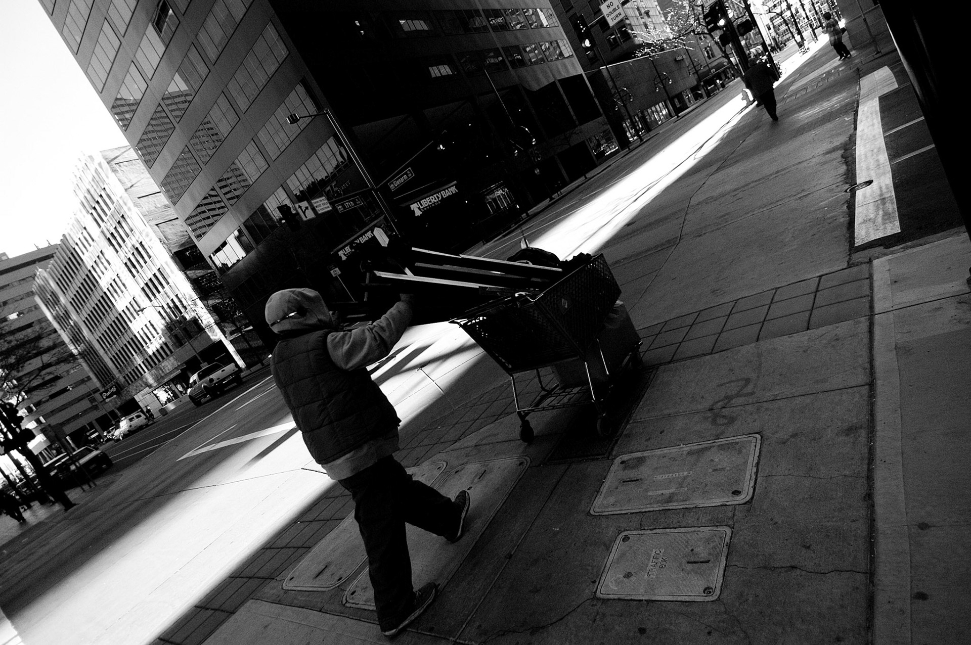 Early in the morning, while most people are hustling toward work, the streets are full of men and women like this - people whose entire homes are held within the bounds of borrowed shopping carts.