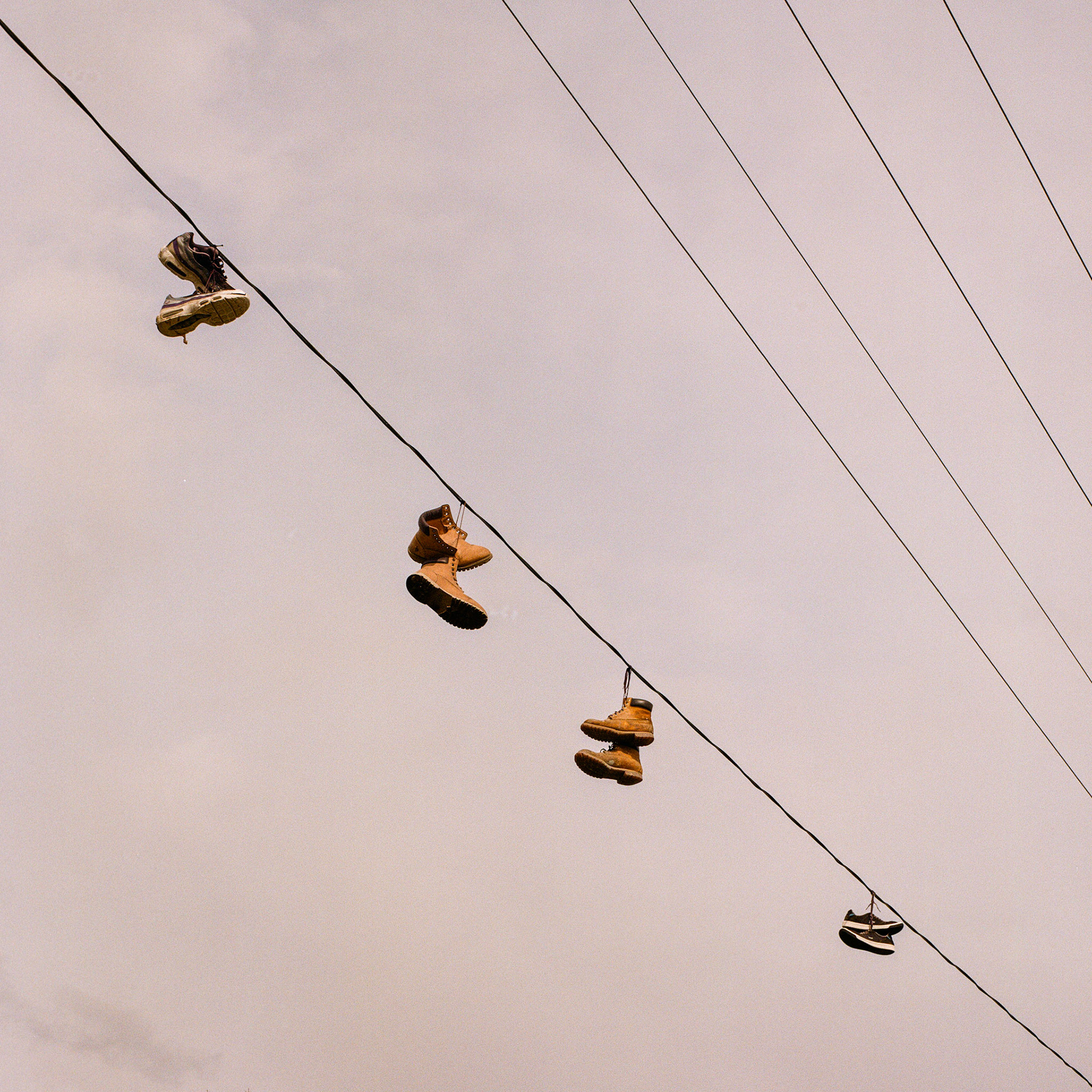 Perhaps you heard that birds on a wire are actually government drones recharging their batteries. Well, here are some boots on a wire. What are they doing there?