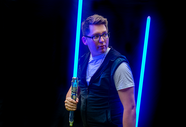 Creative portrait session utilizing the dramatic illumination of combat-ready lightsabers to produce a bold, cinematic profile image.