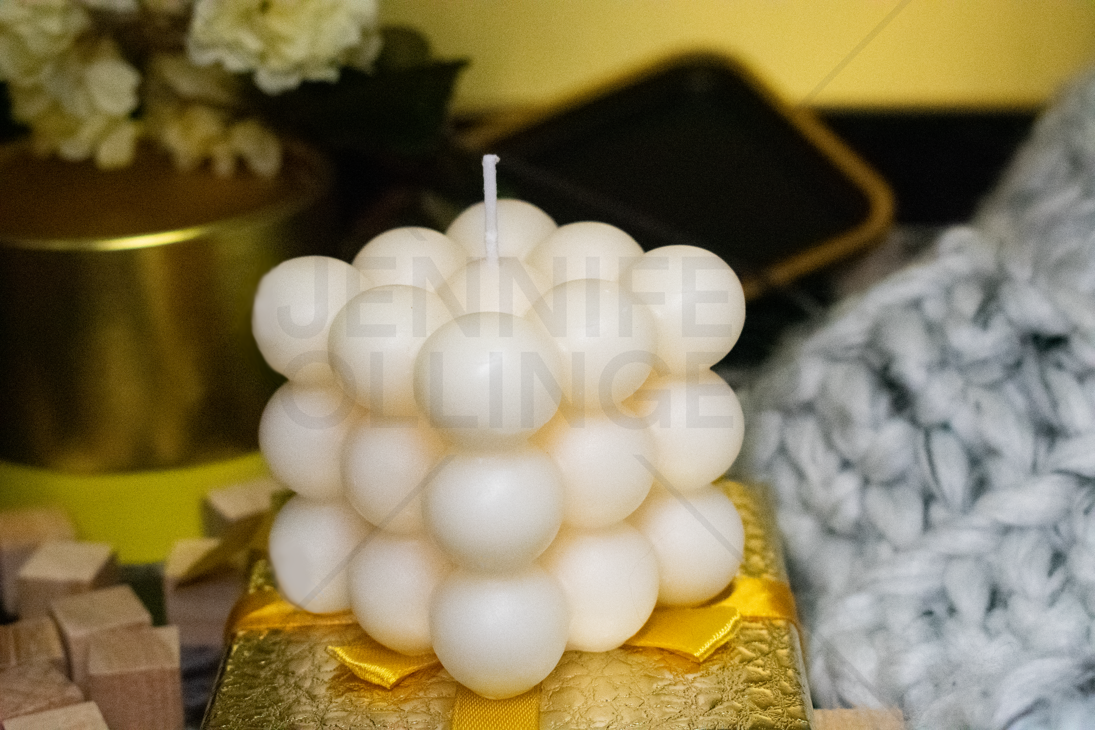 Gift-focused product photography pairing the candle with complementary textures and materials to reinforce its fragrance profile and gifting appeal.