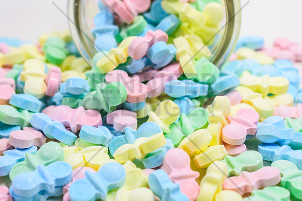 Product photography featuring Sweet Tart Pacifiers arranged outside the packaging to showcase product quantity, shape, and visual appeal for Amazon listings.