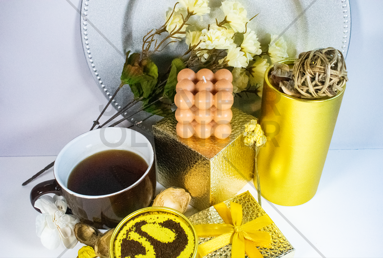 Lifestyle product photography incorporating coffee and florals to evoke the candle's ambiance and everyday use.