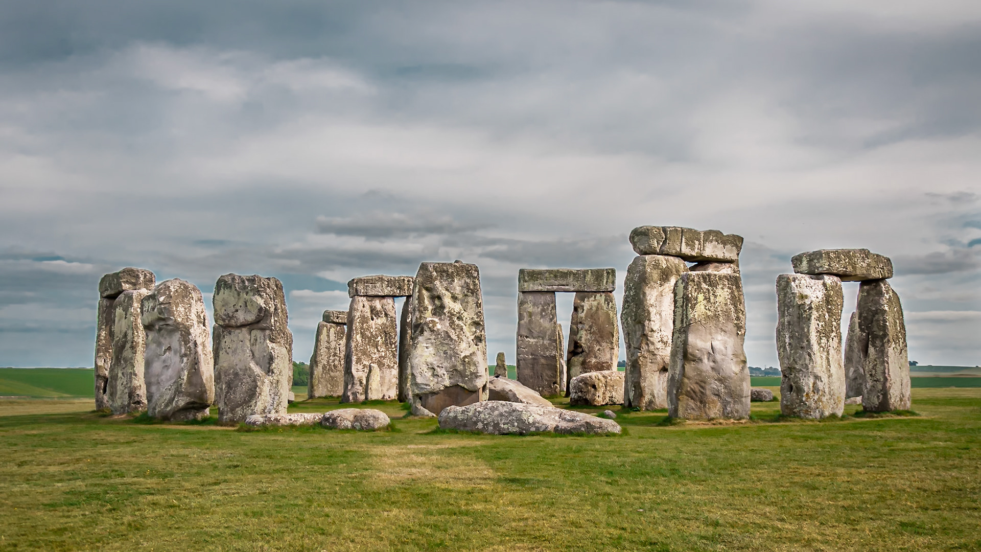 (ES) Stonehenge se encuentra ubicado en Wiltshire, Inglaterra. Es una de las maravillas del mundo y el monumento prehistórico más conocido en Europa.Está formado por grandes bloques de piedra metamórfica distribuidos en cuatro circunferencias concéntricas. La exterior, de treinta metros de diámetro, está formada por grandes piedras rectangulares de arenisca, quedando hoy en día sólo siete en su sitio. Dentro de esta hilera exterior se encuentra otro círculo de bloques más pequeños de arenisca azulada. Éste encierra una estructura con forma de herradura construida con piedras de arenisca del mismo color. En su interior permanece una losa de arenisca micácea conocida como "el Altar".Todo el conjunto está rodeado por un foso circular que mide 104 metros de diámetro. Dentro de este espacio hay 56 fosas conocidas como los «agujeros de Aubrey».La finalidad que tuvo la construcción de este gran monumento se ignora, pero se supone que se utilizaba como templo religioso, monumento funerario u observatorio astronómico que servía para predecir las estaciones.(EN) Stonehenge its located in Wiltshire, England. Is one of the wonders of the world and the best-known prehistoric monument in Europe. It consists of large blocks of metamorphic stone in four concentric circles . The exterior, thirty feet in diameter, made of large rectangular stones of sandstone, and only seven of them remain in place today. Within this outer row, there is another circle of smaller blue sandstone blocks that contains a horseshoe-shaped structure built with stones of the same color sandstone. Inside remains a slab of micaceous sandstone known as "the Altar".The whole is surrounded by a circular pit measuring 341feet in diameter. Within this space there are 56 pits known as "Aubrey's holes".The purpose was to build this great monument is unknown, but is supposed to be used as a religious temple, funeral memorial or astronomical observatory that was used to predict the seasons.