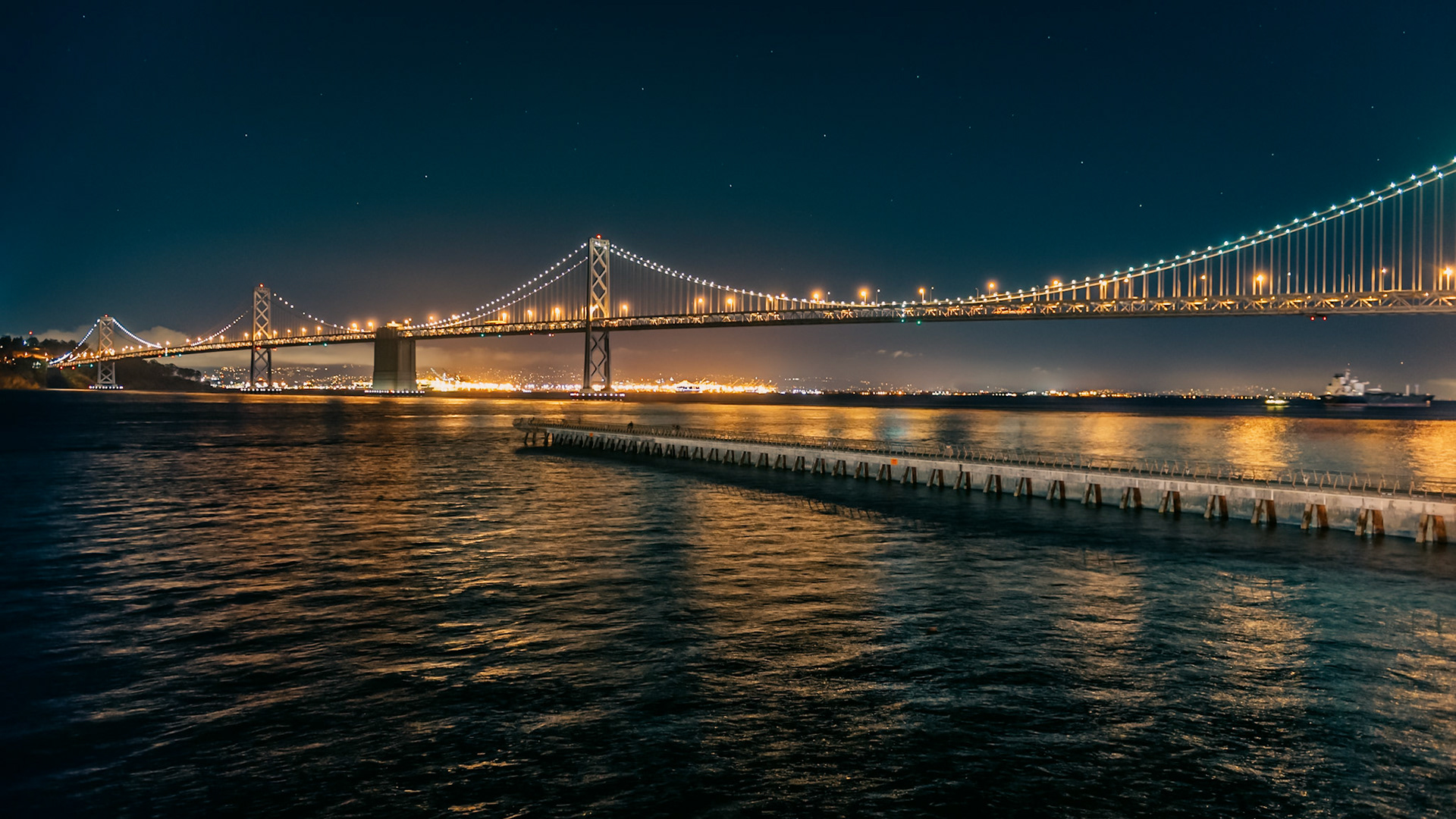 (EN) The San Francisco - Oakland Bay Bridge (known locally as the Bay Bridge), is a suspension bridge linking San Francisco with the city of Oakland, in California, United States. Its length is 10,176 ft.
(ES) El puente de la Bahía de San Francisco-Oakland, más conocido como el Puente de la Bahía, es un puente colgante que une la ciudad de San Francisco con la ciudad de Oakland, en California, Estados Unidos. Su longitud es de 3,102 metros.