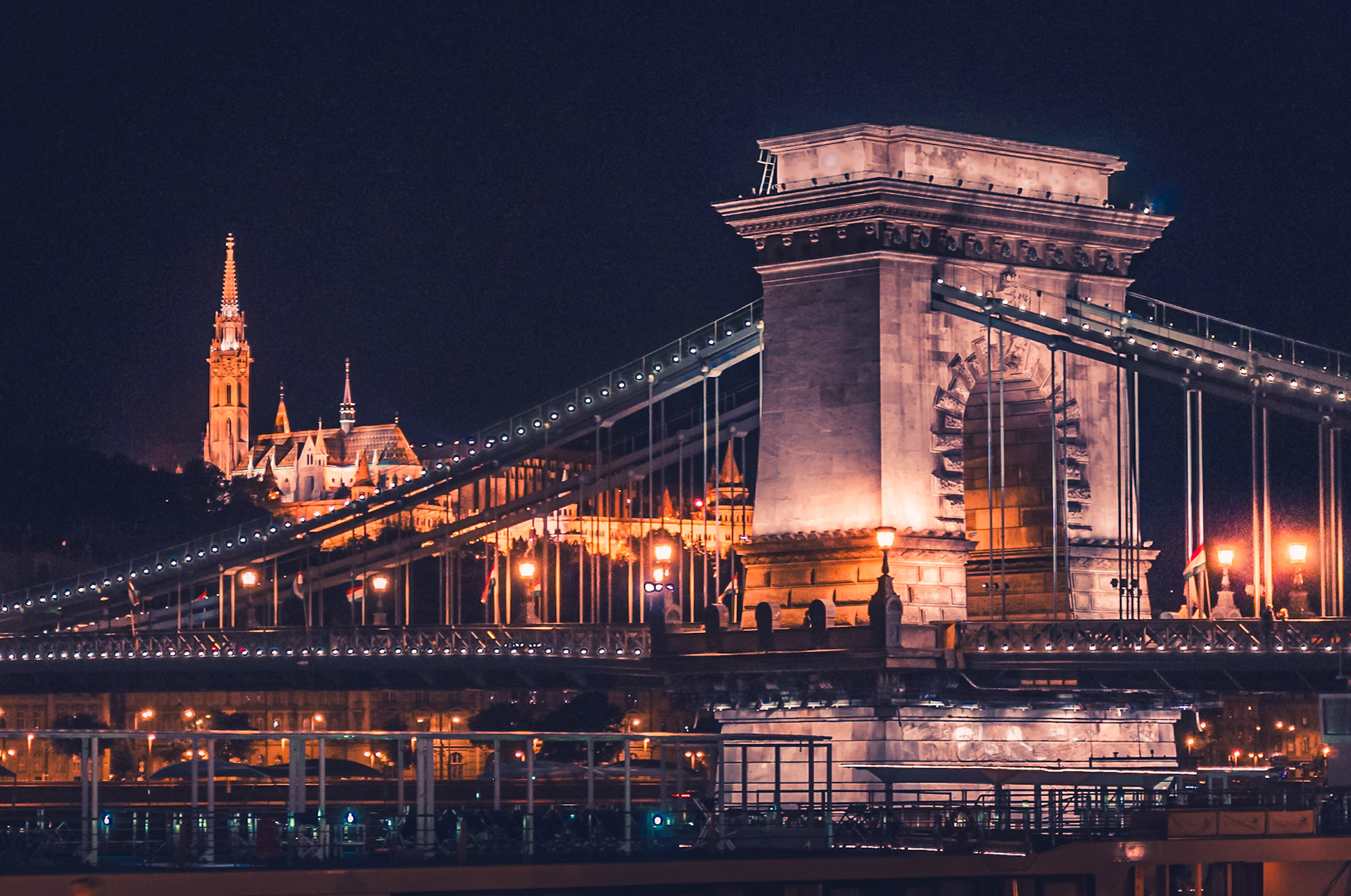 (ES) El Puente de las Cadenas (en húngaro, Széchenyi lánchíd) de Budapest es el más antiguo de los puentes colgantes que unen las dos ciudades Buda y Pest cruzando el rio Danubio, que hoy conforman la capital de Hungría. Se comenzó a construir en 1839 y se inauguró en 1849. Al final de la Segunda Guerra Mundial las tropas alemanas dinamitaron el puente, junto con los otros cuatro de la ciudad en su retirada ante el asedio de Budapest por las tropas soviéticas. El puente reconstruido se inauguró el 21 de noviembre de 1949, festejando el primer centenario de su construcción. (EN) The Chain Bridge (in Hungarian, Széchenyi Chain Bridge) at Budapest is the oldest of the suspension bridges linking the two cities Buda and Pest across the Danube River, which today form the capital of Hungary.It was opened in 1839 and at the end of World War II, the German troops destroyed the bridge before the siege of Budapest by Soviet troops. The reconstructed bridge was inaugurated in November 1949, celebrating the centenary of its construction.