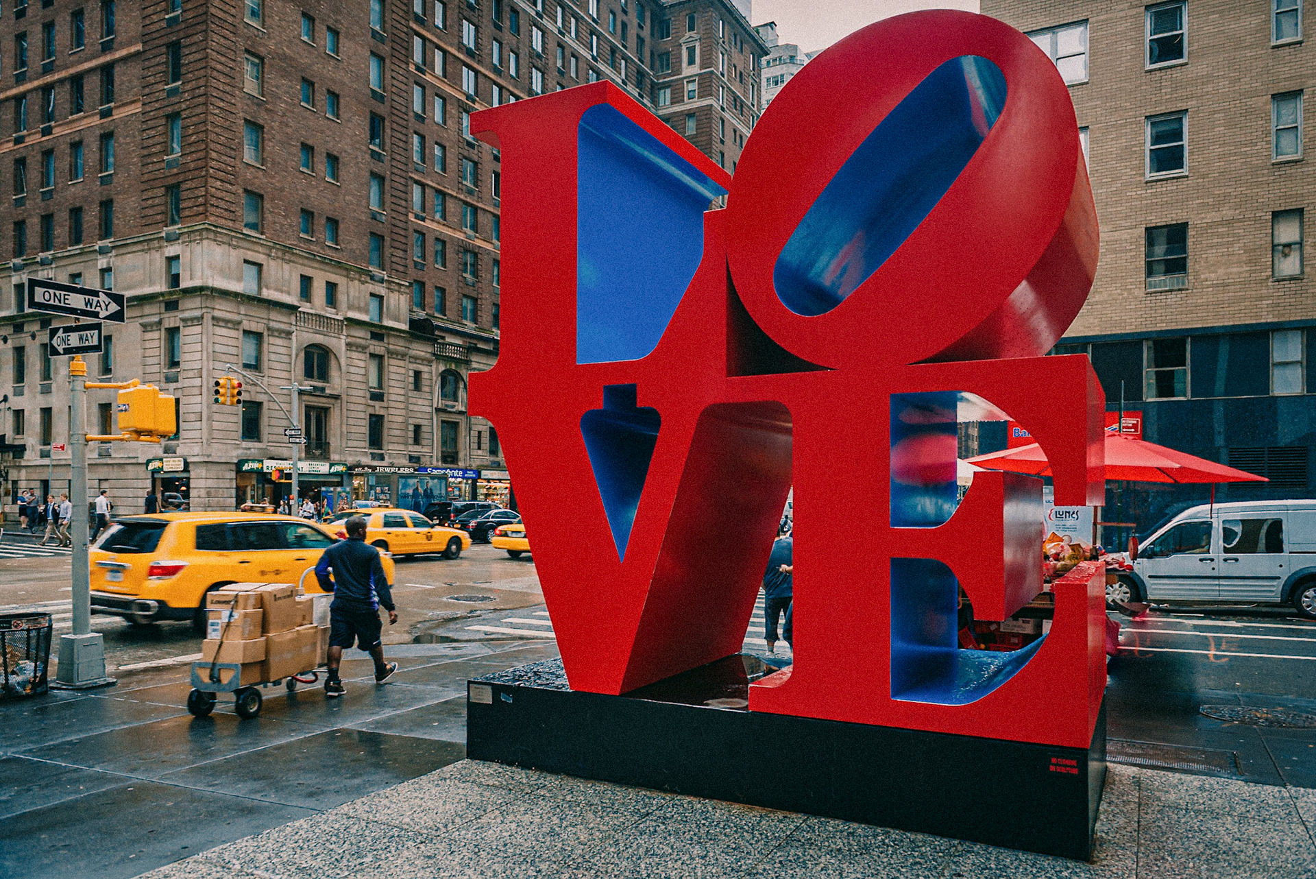 (EN) LOVE is a pop art image by American artist Robert Indiana. It consists of the letters L and O over the letters V and E in bold Didone type; the O is slanted sideways so that its oblong negative space creates a line leading to the V. The original image, with green and blue spaces backing red lettering, served as a print image for a Museum of Modern Art Christmas card in 1965. In much this same form the design soon graced a popular US postage stamp.Love's original rendering in sculpture was made in 1970 and is displayed in Indiana at the Indianapolis Museum of Art. The material is COR-TEN steel. Indiana's Love design has since been reproduced in a variety of formats for rendering in displays around the world.The one in the picture is the classic one in the corner of W 55th St &, 6th Ave, Nueva York. NY, Estados Unidos (ES)LOVE (amor) es una imagen de arte pop del artista estadounidense Robert Indiana. Consiste en las letras L y O sobre las letras V y E en negrita tipo Didone; la O está inclinada hacia los lados, de modo que su espacio negativo oblongo crea una línea que conduce a la V. La imagen original, con espacios verdes y azules detrás de las letras rojas, sirvió como imagen impresa para una tarjeta de Navidad del Museo de Arte Moderno en 1965. En mucho De la misma forma, el diseño pronto apareció en un popular sello de correos de los Estados Unidos.La representación original de LOVE en escultura se realizó en 1970 y se exhibe en Indiana en el Museo de Arte de Indianápolis. El material es acero COR-TEN. Desde entonces, el diseño Love de Indiana se ha reproducido en una variedad de formatos para renderizar en pantallas de todo el mundo. Ésta está en la esquina de las calles W 55th St y la 6th Ave, Nueva York. NY, Estados Unidos