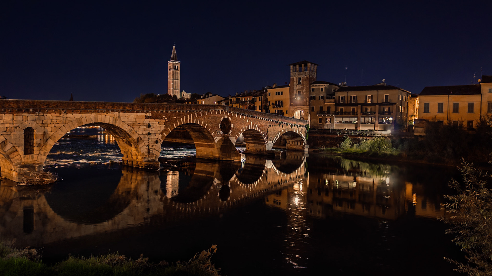 Histórico puente de piedra con arcos romanos restaurado. Verona, Italia.