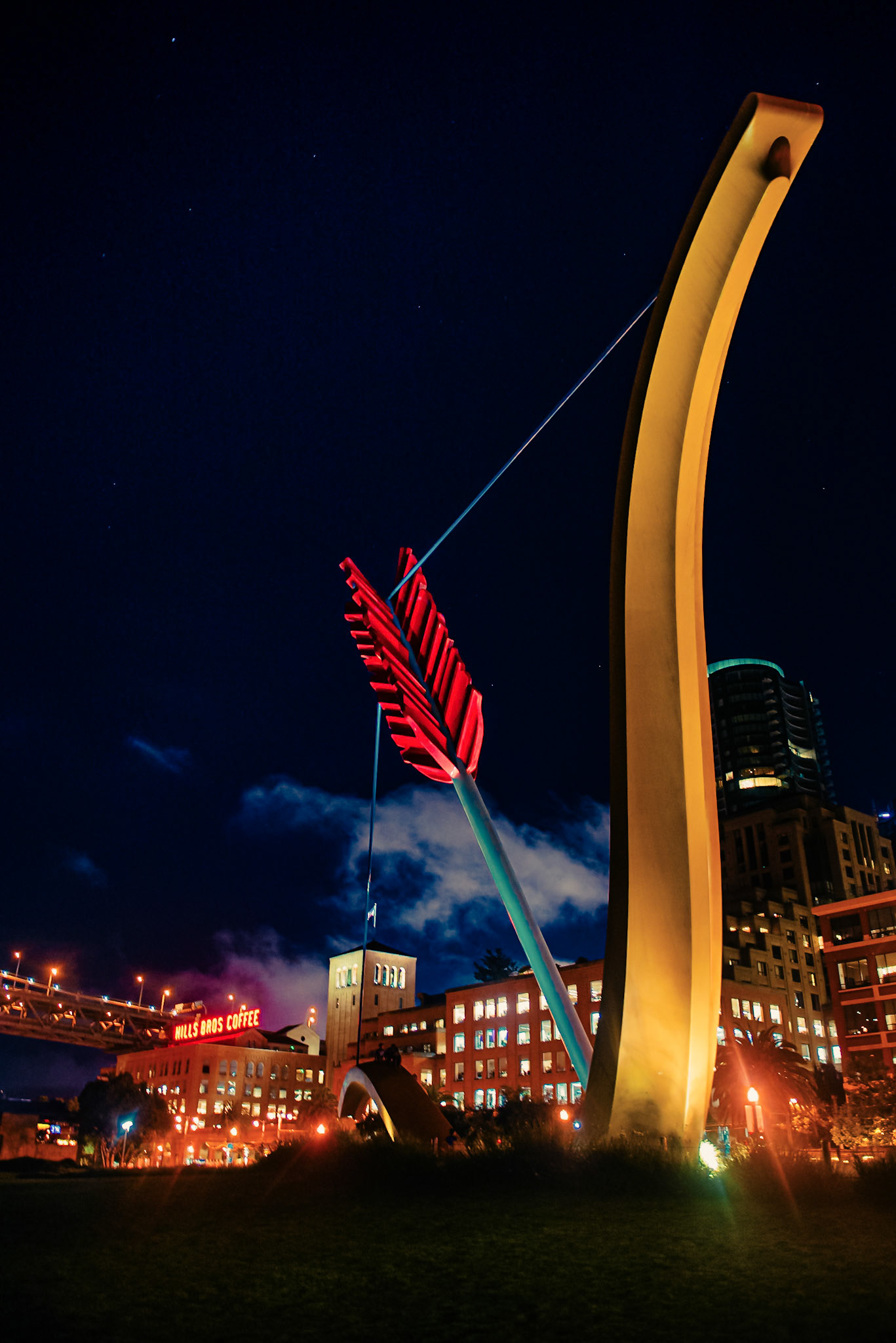 (EN)Cupid's Span is an outdoor sculpture by married artists Claes Oldenburg and Coosje van Bruggen, installed at the Rincon Park near to the Embarcadero in San Francisco, California, in the United States. The piece resembles Cupid's bow and arrow, drawn, with the arrow and bow partially implanted in the ground; the artists stated that the piece was inspired by San Francisco's reputation as the home port of Eros, hence the stereotypical bow and arrow of Cupid. Leydier and Penwarden wrote, "Love's trade-mark weapon naturally evokes the city's permissive and romantic reputation, while formally its taut curve resonates wonderfully with the structure of the famous suspension bridge in the background.(ES)Cupid's Span es una escultura al aire libre del matrimonio de artistas Claes Oldenburg y Coosje van Bruggen en el año 2002 y fue instalada en el Rincon Park que se encuentra en la zona del Embarcadero en San Francisco, California, en los Estados Unidos.La pieza se asemeja al arco y la flecha de Cupido, dibujados, con la flecha y el arco parcialmente implantados en el suelo. Los artistas declararon que la pieza se inspiró en la reputación de San Francisco como el puerto de origen de Eros, de ahí el arco y la flecha estereotipados de Cupido. Leydier y Penwarden escribieron: "El arma del amor" evoca naturalmente la reputación permisiva y romántica de la ciudad, mientras que formalmente su curva tensa resuena maravillosamente con la estructura del famoso puente colgante en el fondo.