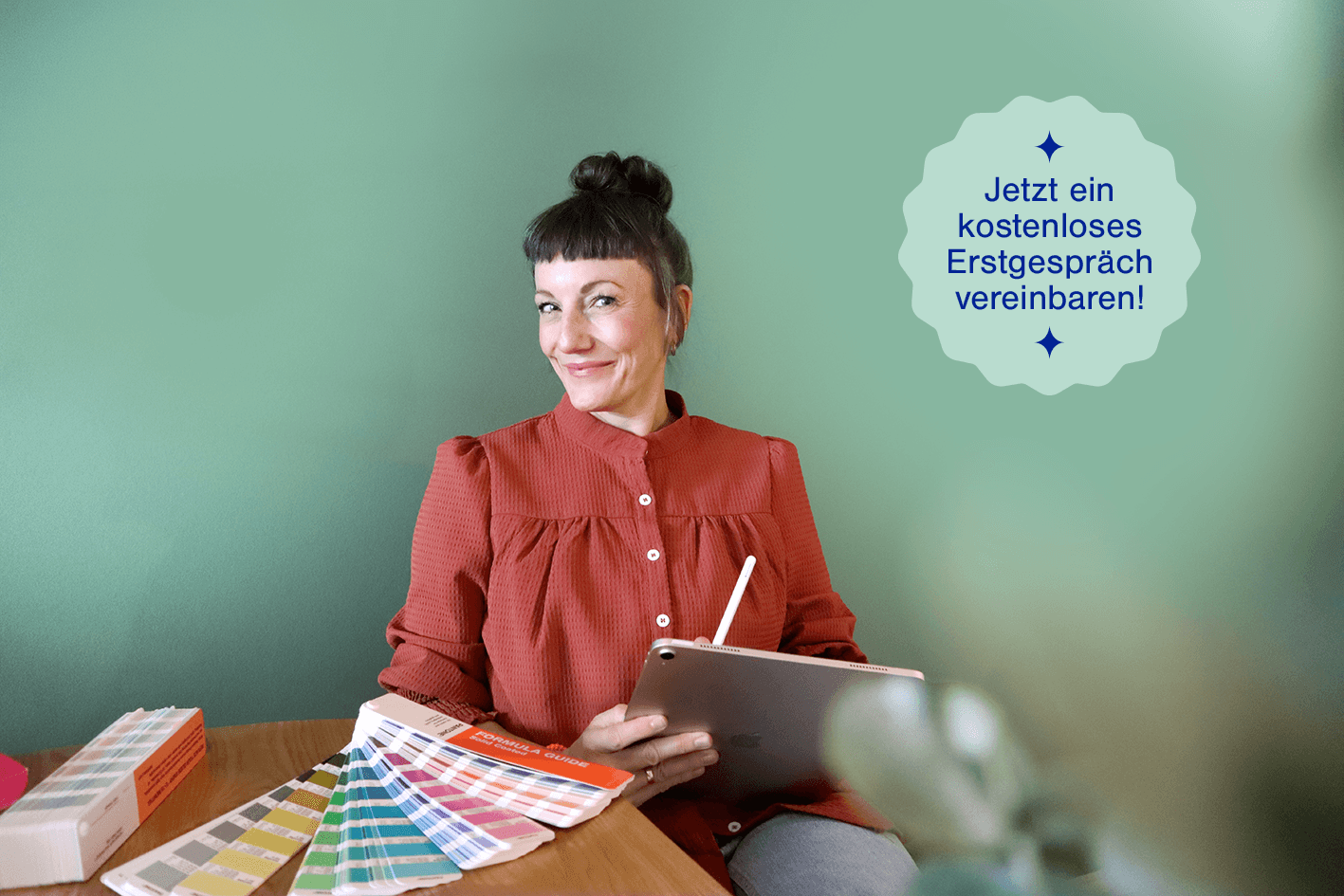 Stefanie Twellmann bei der Arbeit, mit iPad und Pantonefächer – Jetzt ein gratis Erstgespräch vereinbaren!