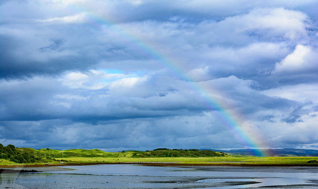 Rainbow and clouds above a lake