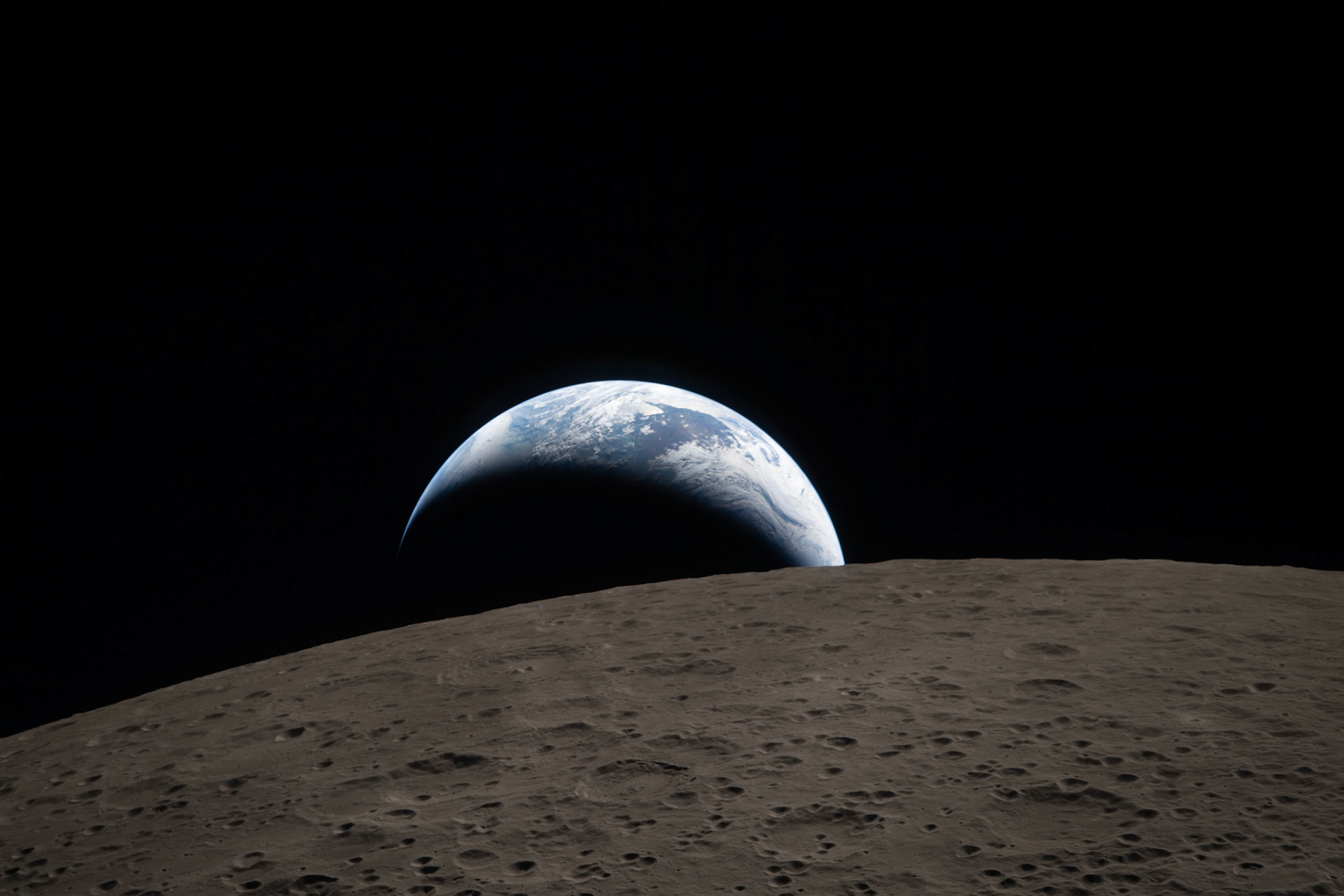 art002e009288 (April 6, 2026) – Earthset captured through the Orion spacecraft window at 6:41 p.m. EDT, April 6, 2026, during the Artemis II crew’s flyby of the Moon. A muted blue Earth with bright white clouds sets behind the cratered lunar surface.The dark portion of Earth is experiencing nighttime. On Earth’s day side, swirling clouds are visible over the Australia and Oceania region.  In the foreground, Ohm crater has terraced edges and a flat floor interrupted by central peaks. Central peaks form in complex craters when the lunar surface, liquefied on impact, splashes upwards during the crater’s formation.