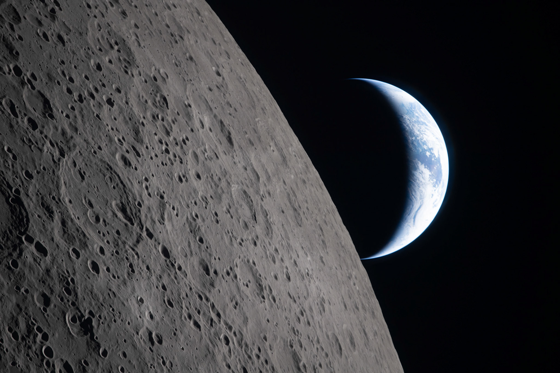 art002e009286 (April 6, 2026) – As the Artemis II crew came close to passing behind the Moon and experiencing a planned loss of signal, they captured this image of a crescent Earth setting on the Moon’s limb. The edge of the visible surface of the Moon is called the “lunar limb.” Seen from afar, it almost looks like a circular arc – except when backlit, as in other images captured by the Artemis II crew.In this photo, the dark portion of Earth is experiencing nighttime, while Australia and Oceania are in the daylight. In the foreground, the Ohm crater is visible, with terraced edges and a flat floor interrupted by central peaks. Peaks such as these form in complex craters when the lunar surface is liquified on impact, and the liquefied surface splashes upward during the crater’s formation.
