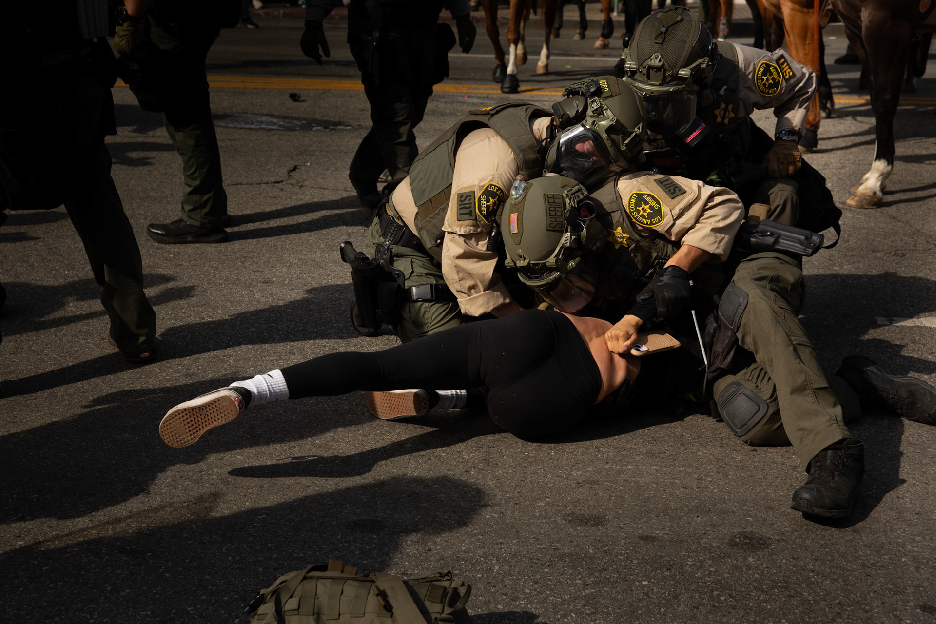 Los Angeles County Shriffs tackle and apply plastic zip ties to a demonstrator during a march against the Trump Military Parade and immigration raids by ICE in Downtown Los Angeles on June 13, 2025