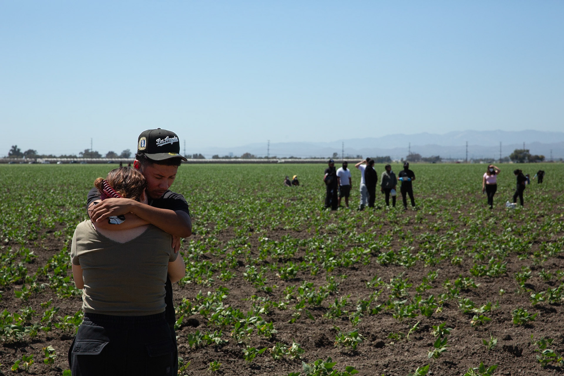 Judith Ramos 22 and Aauro Rangel 20 embrace in a field. Ramos lost contact with her father who is a worker at a Camarillo farm being raided by ICE. DHS agents from multiple subsidiaries conducts a mass raid at a farm in Camarillo, Calif. on July 10, 2025.