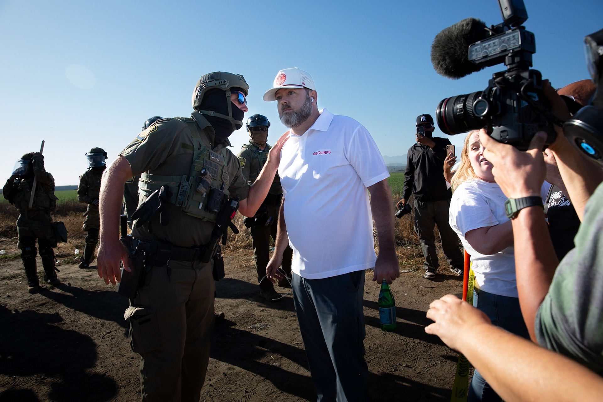 DHS agents talk to a Pro Trump protestor who taunts civilians gathered at the farm. DHS agents from multiple subsidiaries conducts a mass raid at a farm in Camarillo, Calif. on July 10, 2025.