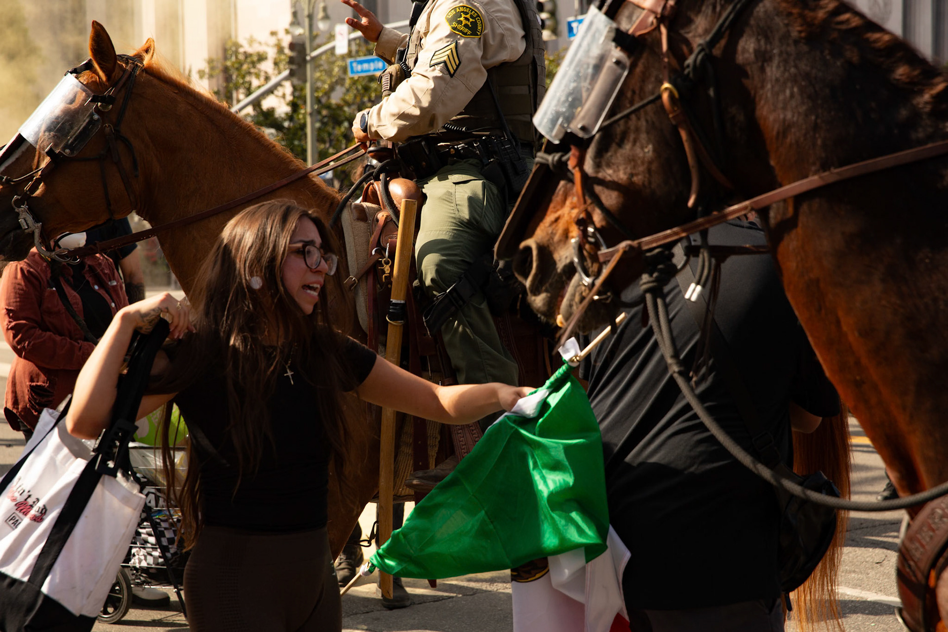 A demonstrator cries and attempts to rescue her cousin who is being tackled and plastic zip tied by Los Angeles County Shriffs during a march against the Trump Military Parade and immigration raids by ICE in Downtown Los Angeles on June 13, 2025