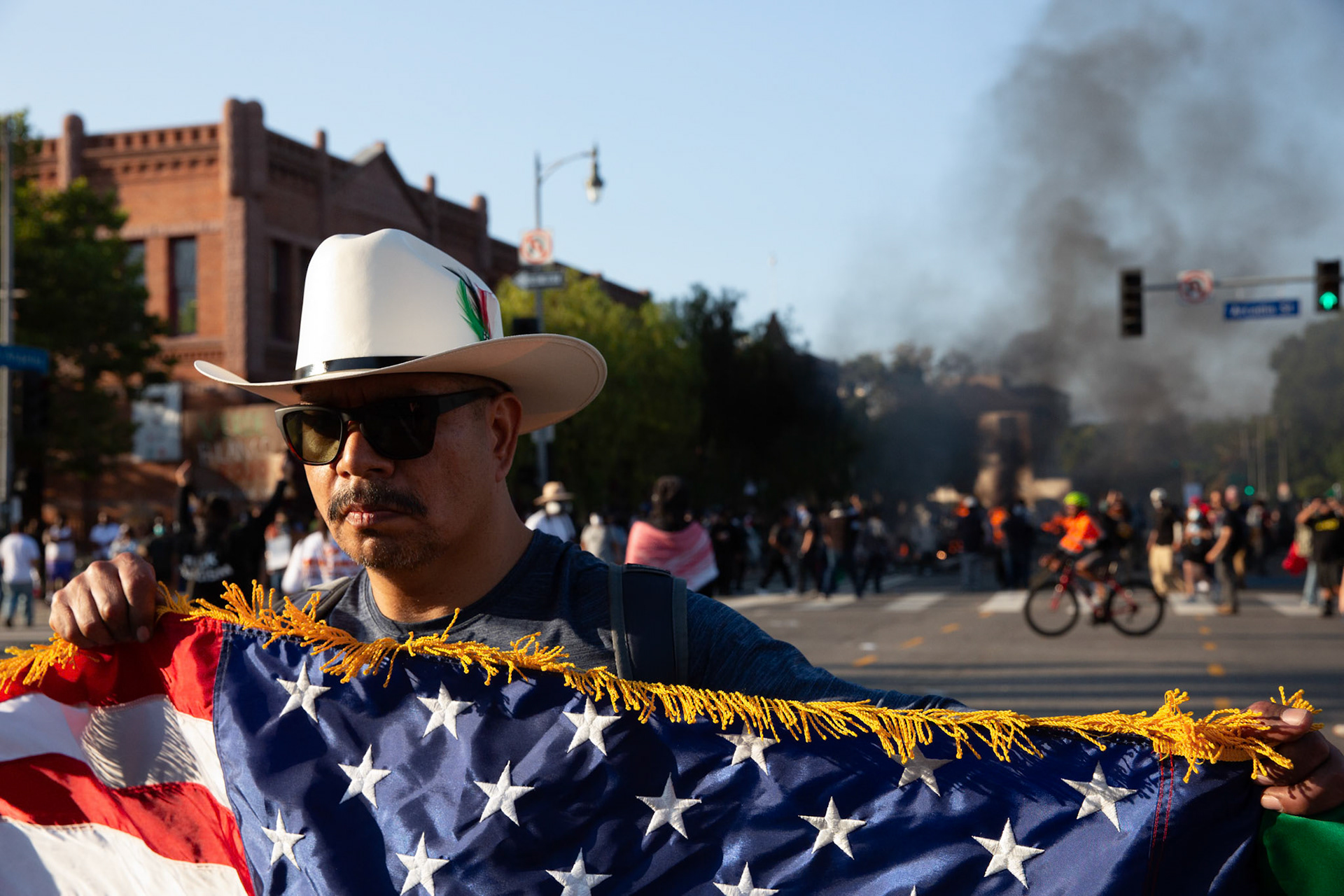 A demonstrator displays an American flag in Donwtown Los Angeles, Calif. on June 8, 2025 during a protest against immigration raids conducted by ICE and Federal police.