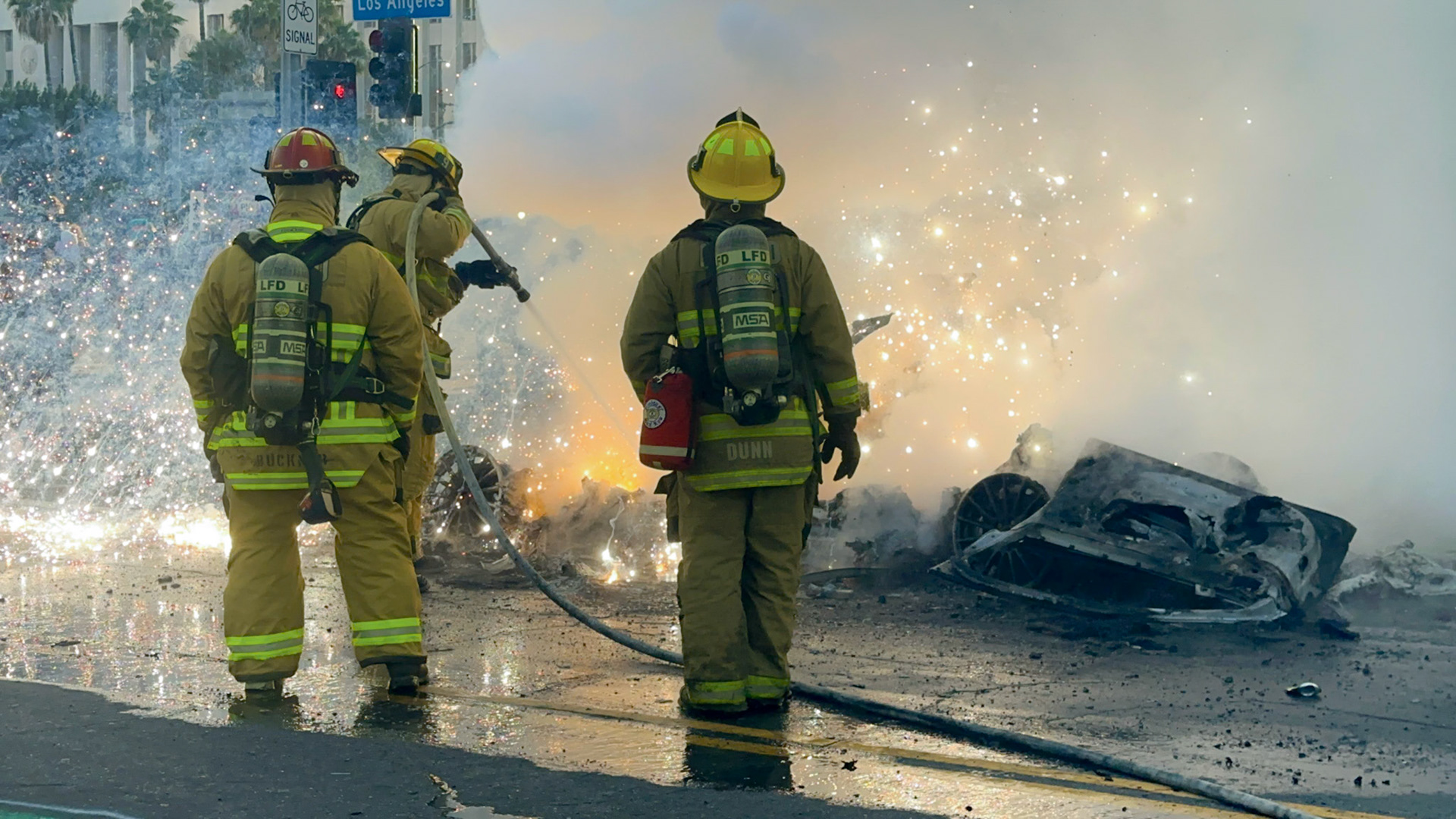 Electrical sparks fly as friefighters extinguish driverless robo-taxis in Donwtown Los Angeles, Calif. on June 8, 2025 during a protest against immigration raids conducted by ICE and Federal police.