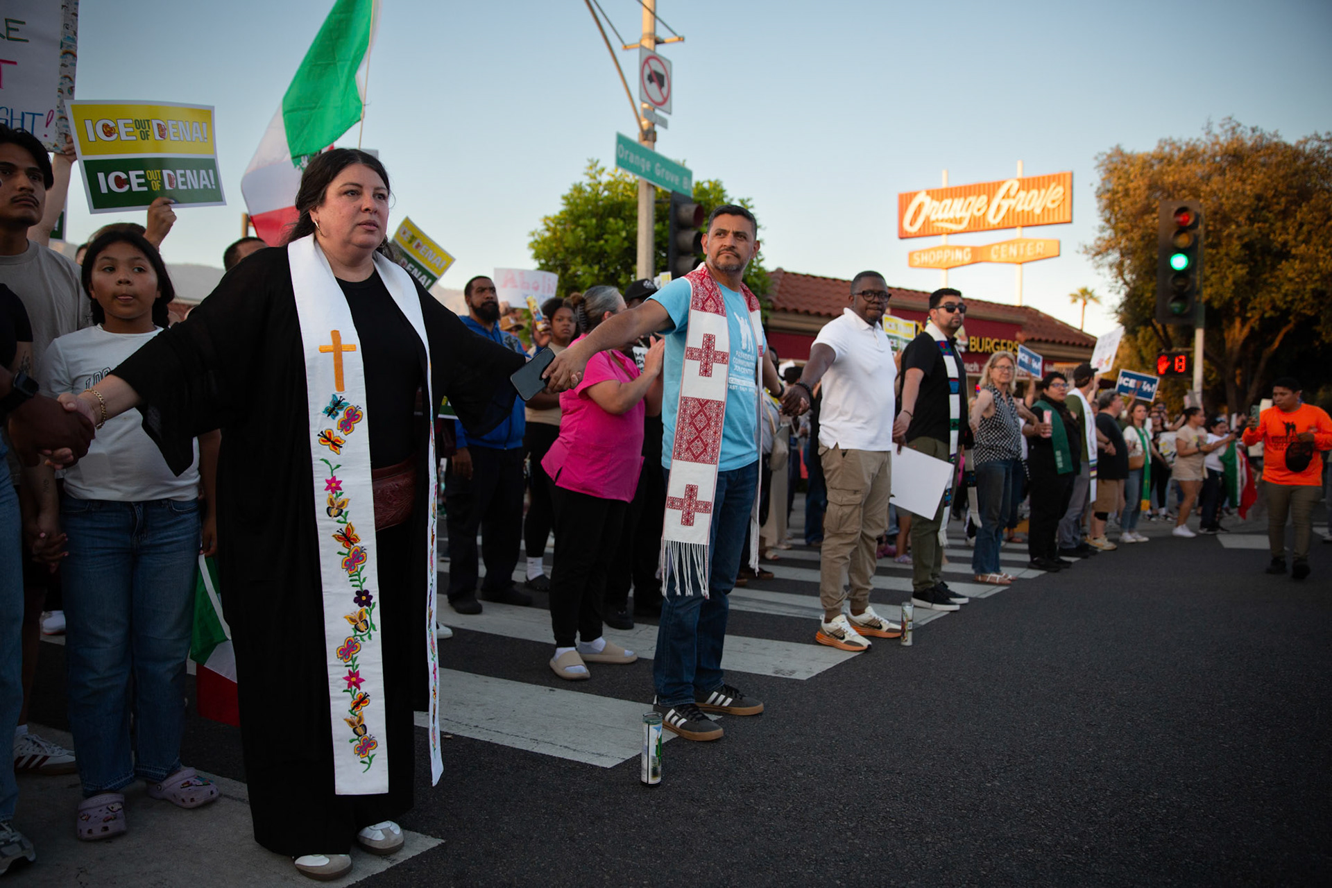 Mayra Macedo-Nolan of Clergy Community Coalition hold hands with clergy from various local religious demoniations to form a human chain in Pasadena, Calif. on June 18, 2025 to demonstrate against immigration raids conducted by ICE and Federal police.