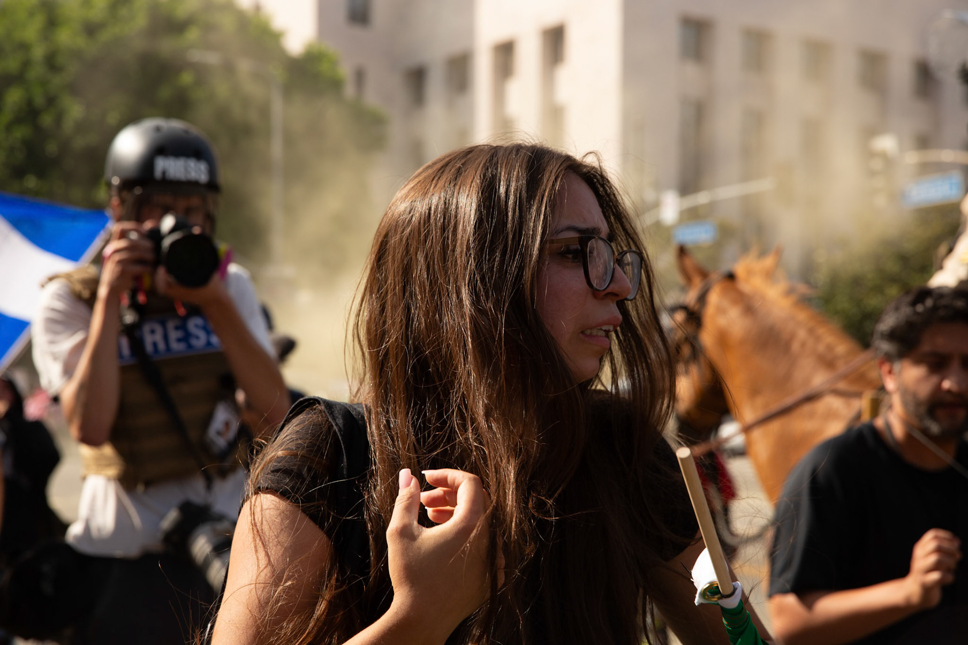 A demonstrator cries and attempts to rescue her cousin who is being tackled and plastic zip tied by Los Angeles County Shriffs during a march against the Trump Military Parade and immigration raids by ICE in Downtown Los Angeles on June 13, 2025