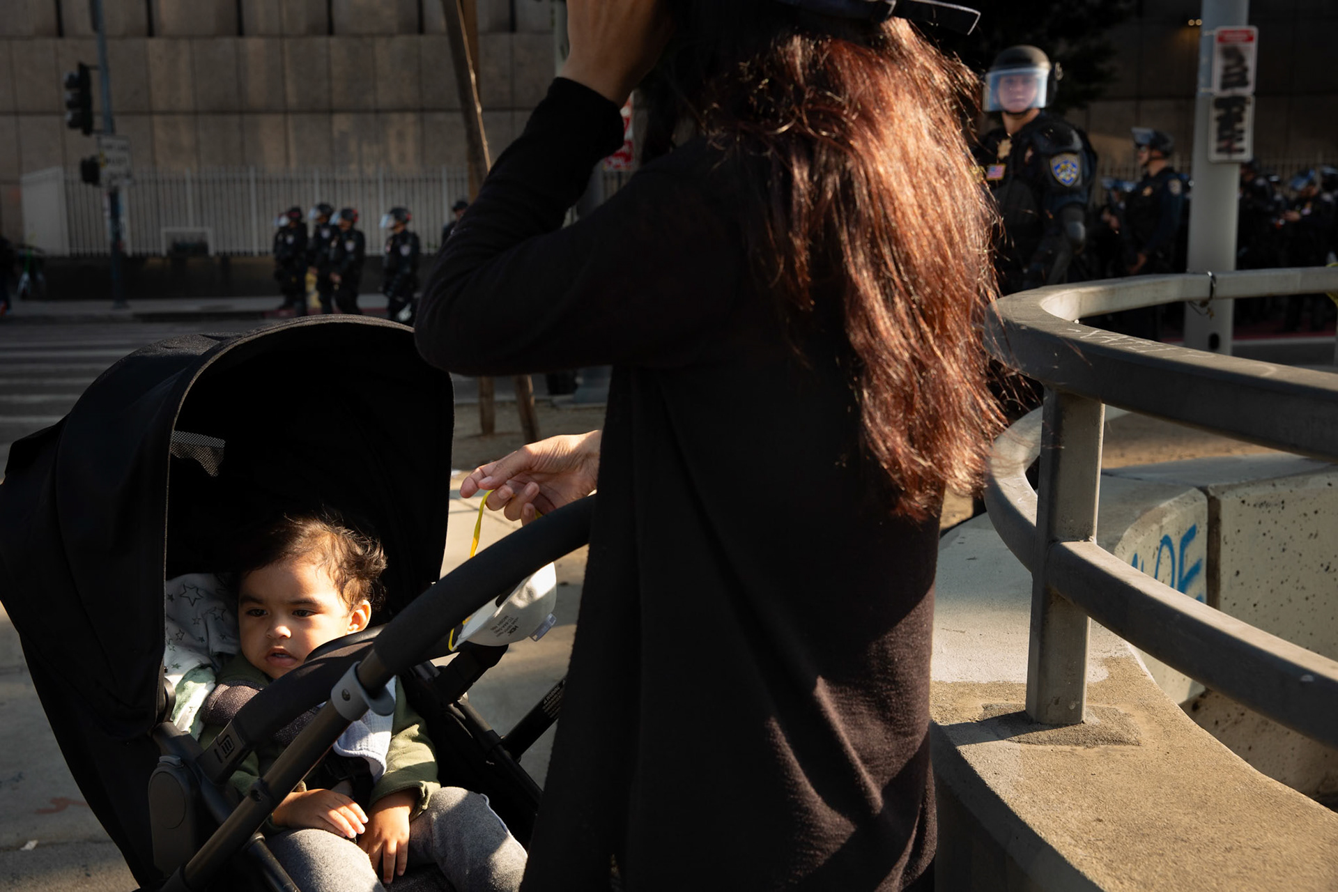 Sara waits with her son Jobie (1) by the U.S. Department of Homeland Security-Immigration and Customs Enforcement building in Downtown Los Angeles, Calif. on June 13, 2025 while her partner attends a protest against immigration raids conducted by ICE and Federal police.