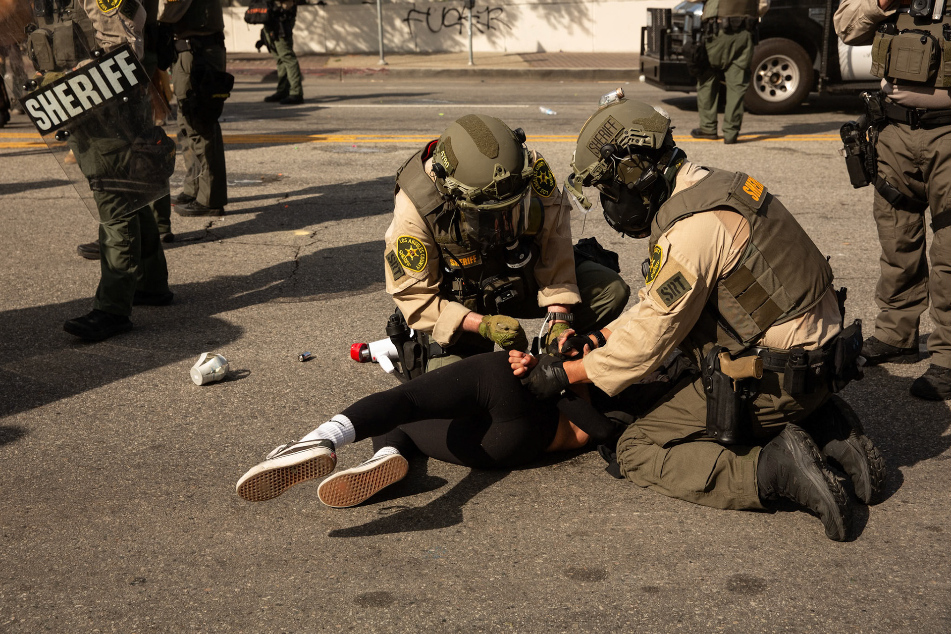 Los Angeles County Shriffs tackle and apply plastic zip ties to a demonstrator during a march against the Trump Military Parade and immigration raids by ICE in Downtown Los Angeles on June 13, 2025