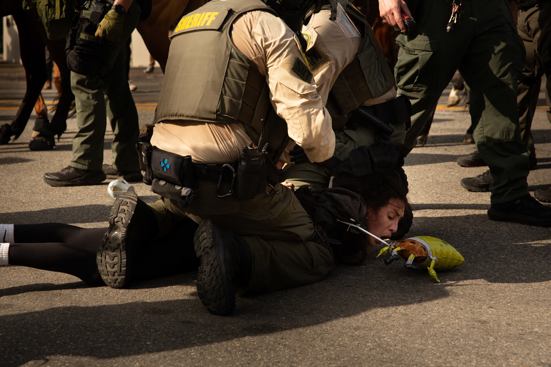 Los Angeles County Shriffs tackle and apply plastic zip ties to a demonstrator during a march against the Trump Military Parade and immigration raids by ICE in Downtown Los Angeles on June 13, 2025