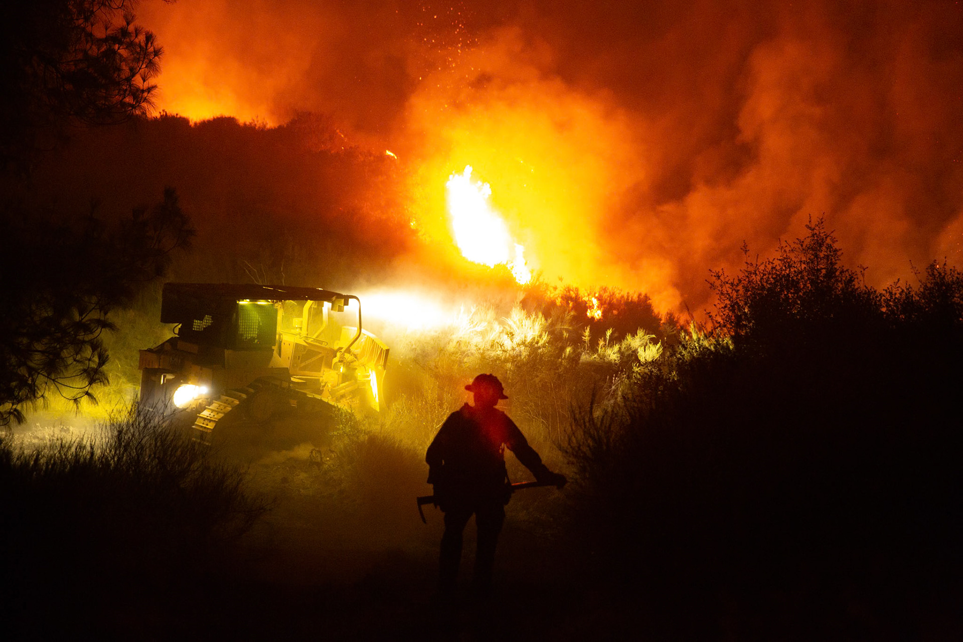 Firefighters use bulldozers and hand tools to remove vegetation in order prevent the wildfire from reaching nearby homes. The Canyon Fire started around 1:30pm on August 7, 2025 and rapidly spread to 600 acres in less than two hours. Aided by the heatwave in Southern California that reached 100 degrees Ferehnehit, dry vegetation, and steep topology; the fire has scorched more than 4,800 acres as of Thursday night.