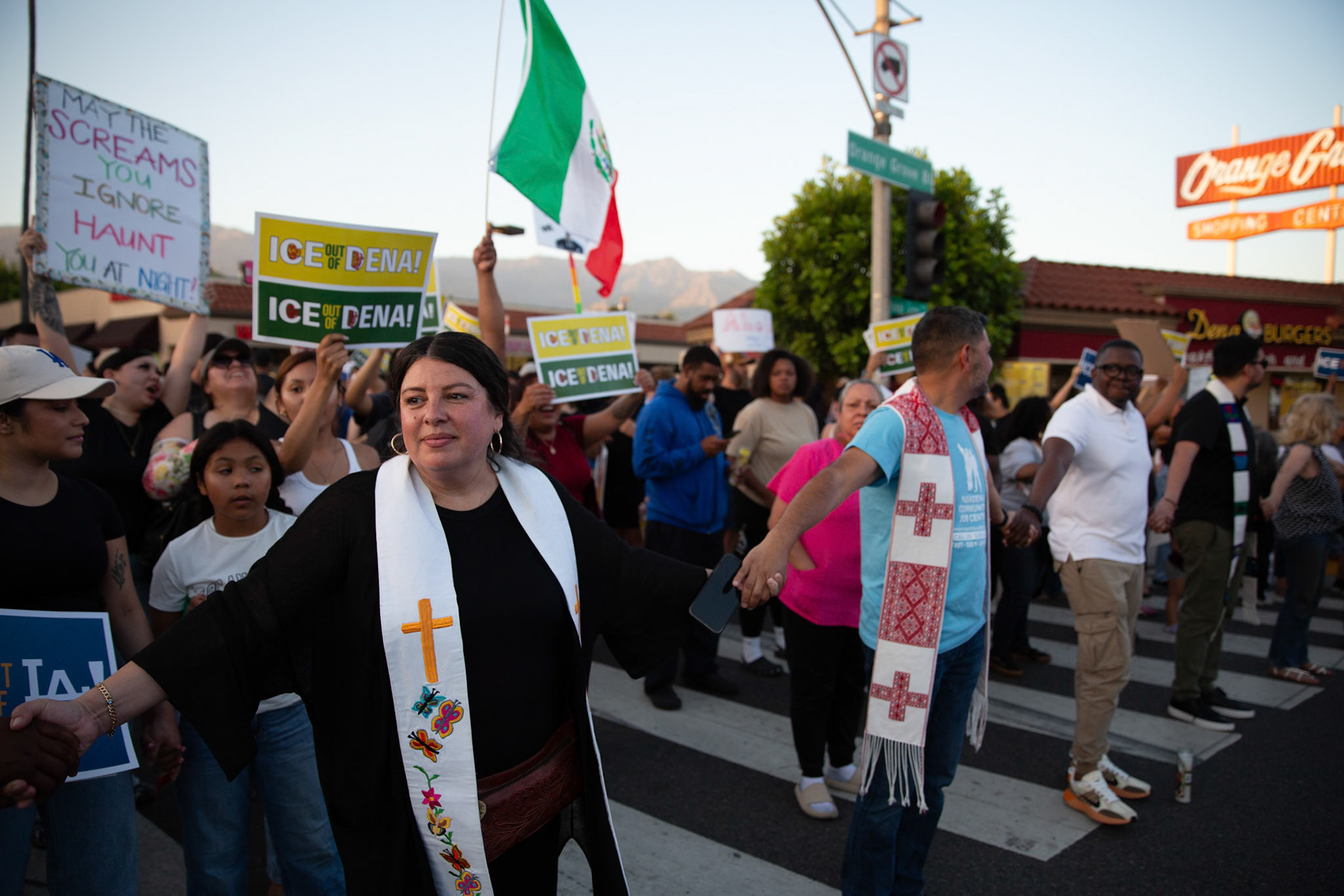 Mayra Macedo-Nolan of Clergy Community Coalition hold hands with clergy from various local religious demoniations to form a human chain in Pasadena, Calif. on June 18, 2025 to demonstrate against immigration raids conducted by ICE and Federal police.