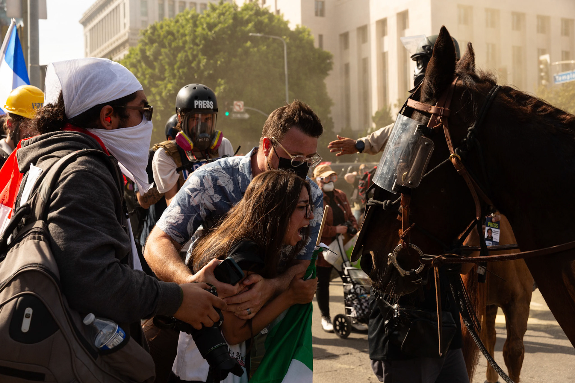 A demonstrator cries and attempts to rescue her cousin who is being tackled and plastic zip tied by Los Angeles County Shriffs during a march against the Trump Military Parade and immigration raids by ICE in Downtown Los Angeles on June 13, 2025