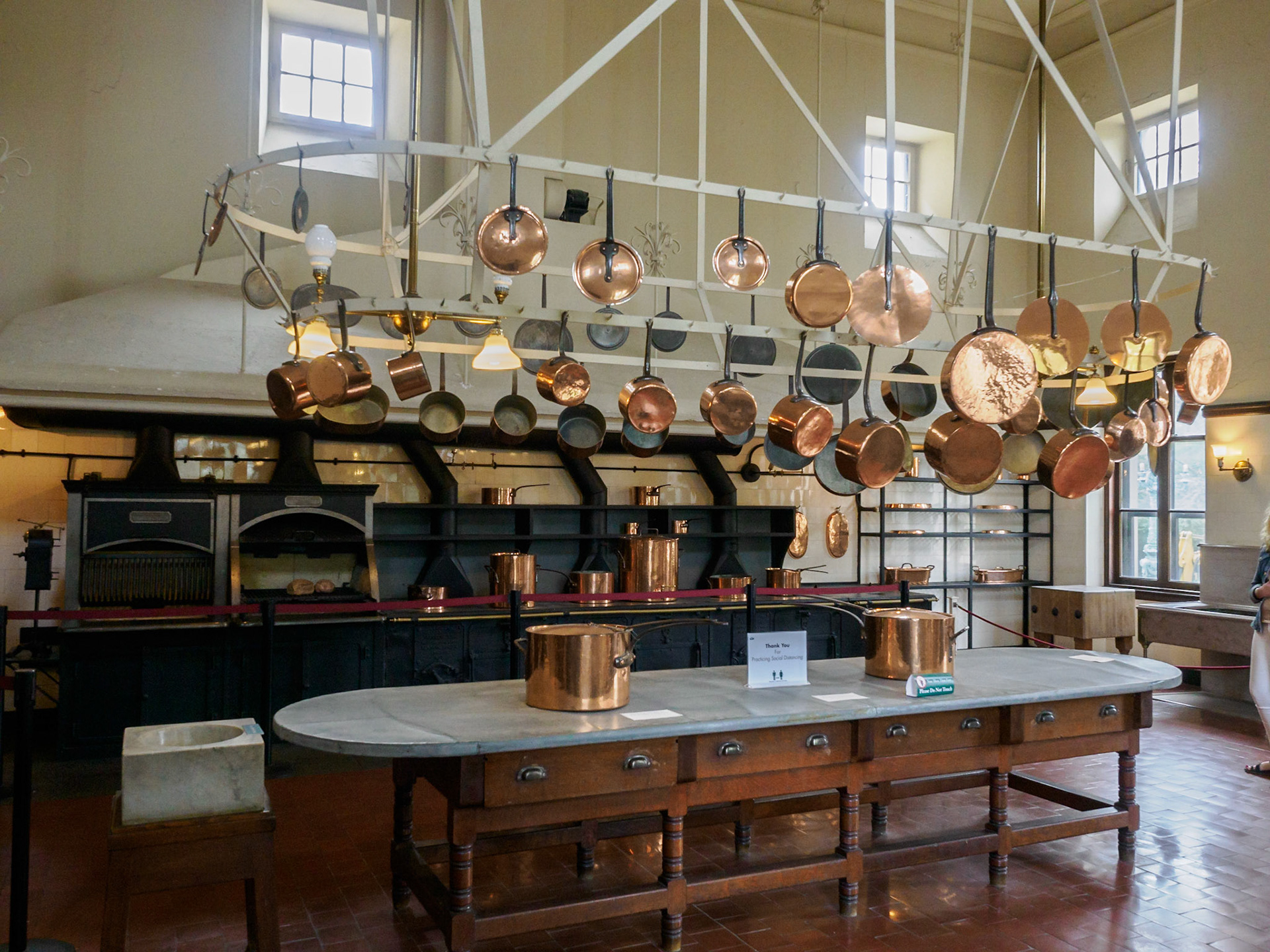 The Kitchen was in a separate wing, safely away from the rest of the house in case of fire. The cast iron coal and wood-burning stoves stretch over 21 feet. The long worktable is covered with zinc, the stainless steel of the day. Copper pots for every imaginable purpose hang above.