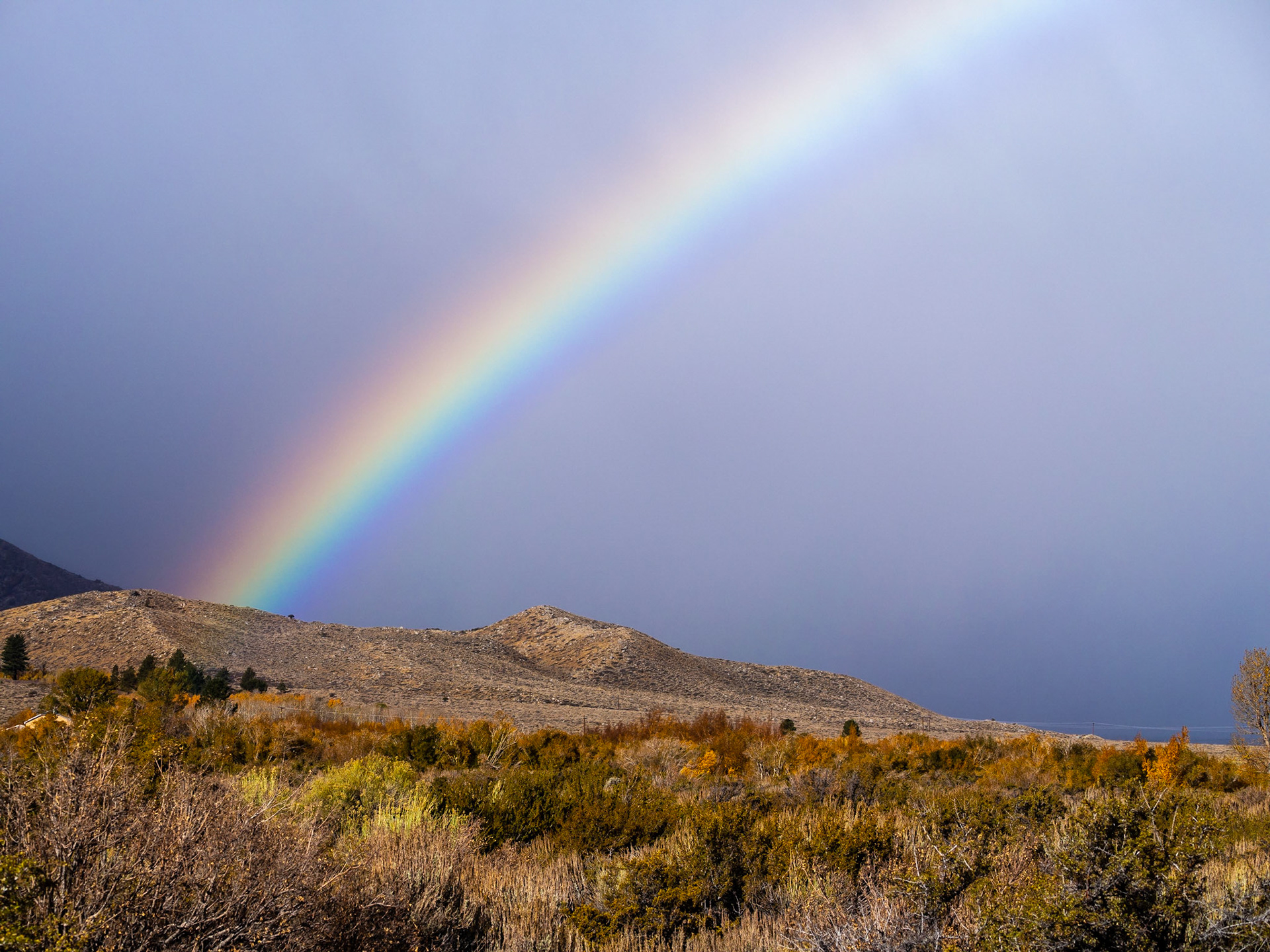 Intense Rainbow Behind the Hills