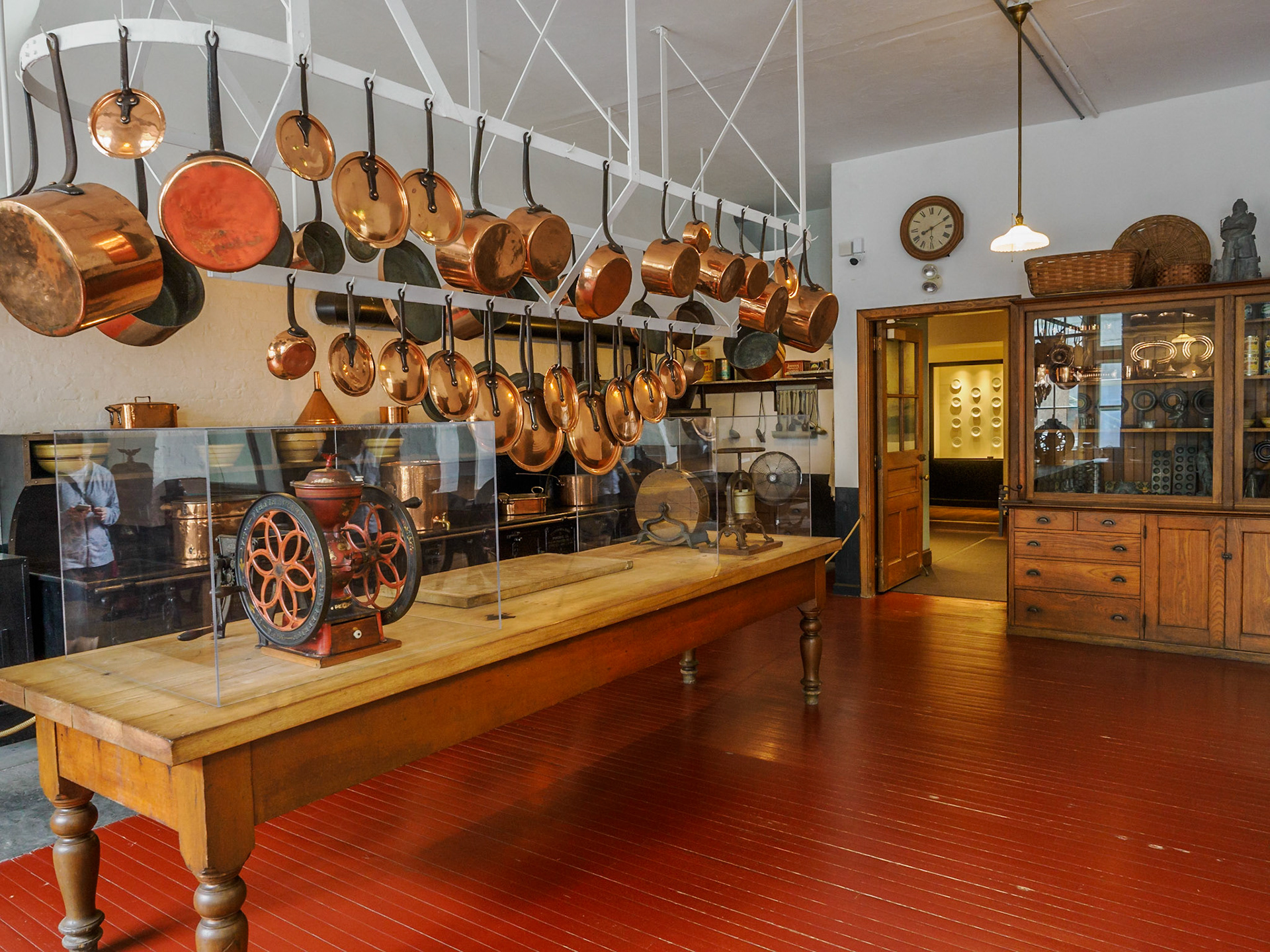 The Marble House's kitchen was equipped to feed hundreds of guests at once. The huge cast iron stove burned 30 tons of coal each summer season. An array of copper pots and pans hang at the ready.