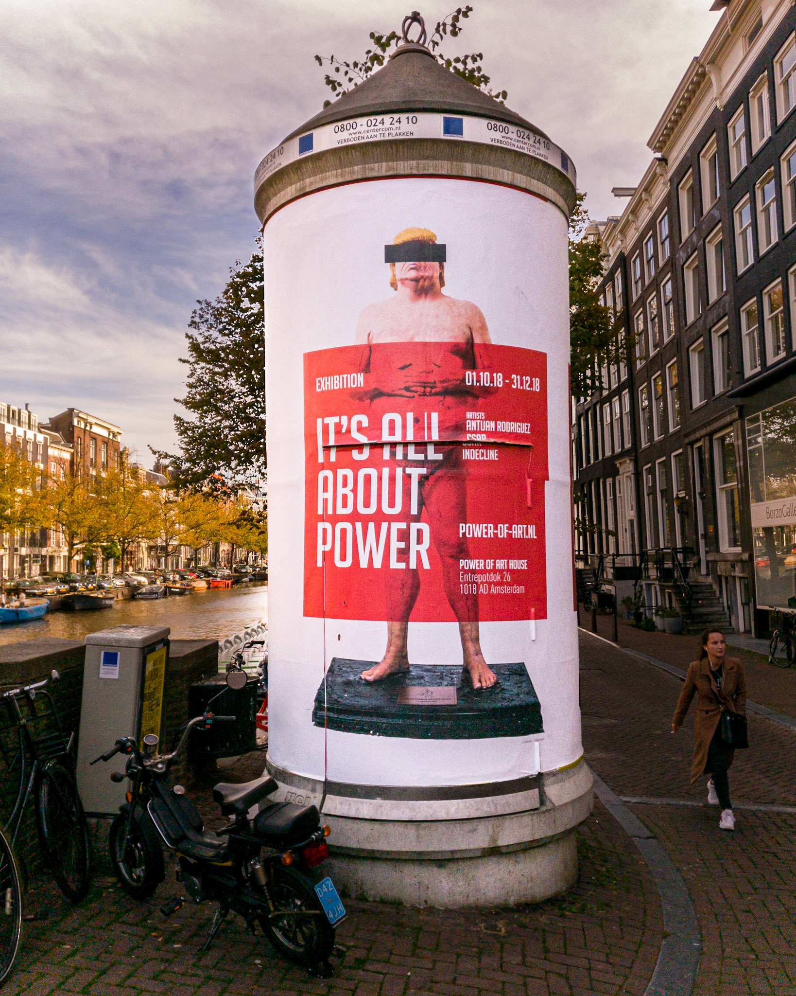 Ad for It's All About Power art exhibition featuring overweight, nude Donald Trump statue in Amsterdam, Netherlands