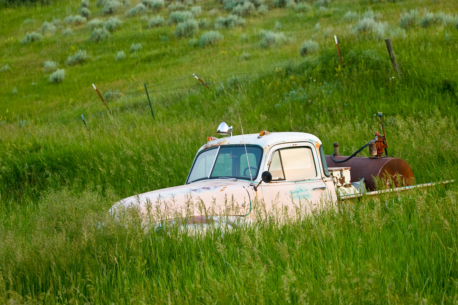 An old fire truck is slowly swallowed by the weeds and grass in a southern Montana field.