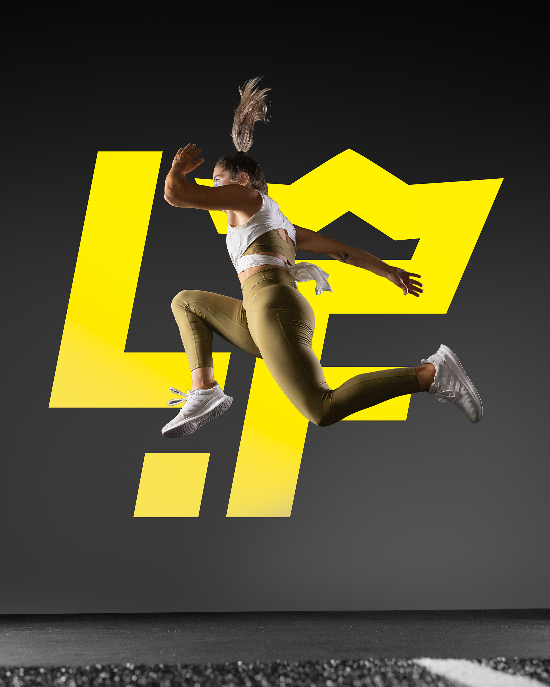 The image features a woman in mid-jump, captured in profile with her hair flowing behind her. She is wearing a white sleeveless top, olive-green leggings, and white sneakers. The background includes a large yellow stylized crown logo, set against a dark backdrop, highlighting the dynamic motion and athletic theme.