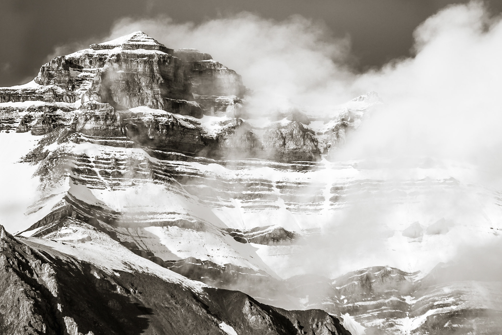 The pyramidal form of Nigel Peak in Jasper National Park, Alberta, Canada is swathed in snow and cloud from a recent squall.